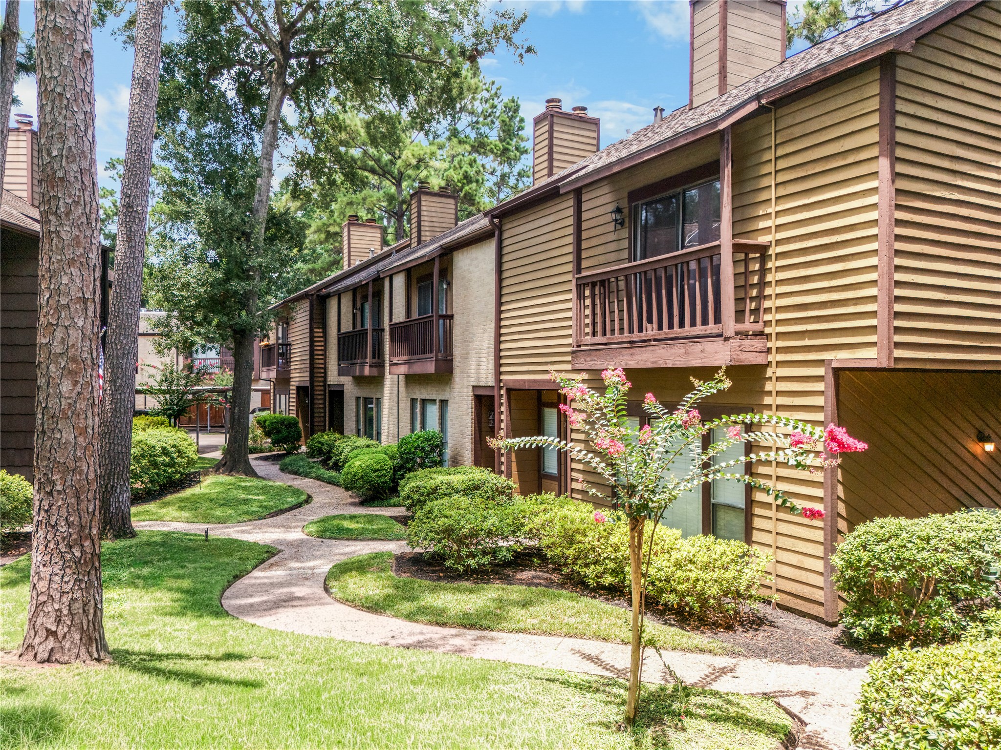 Mature trees and landscaped walkways bring a peaceful, established feel to everyday life at Hudson Oaks.