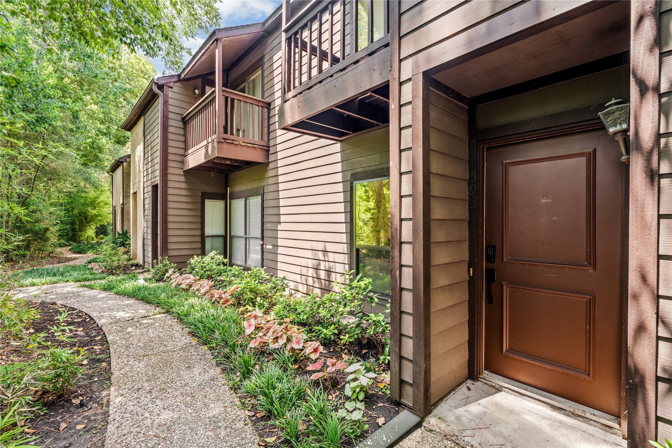 Tucked beneath a canopy of mature trees, the private entrance offers a quiet welcome home within the established Hudson Oaks community.
