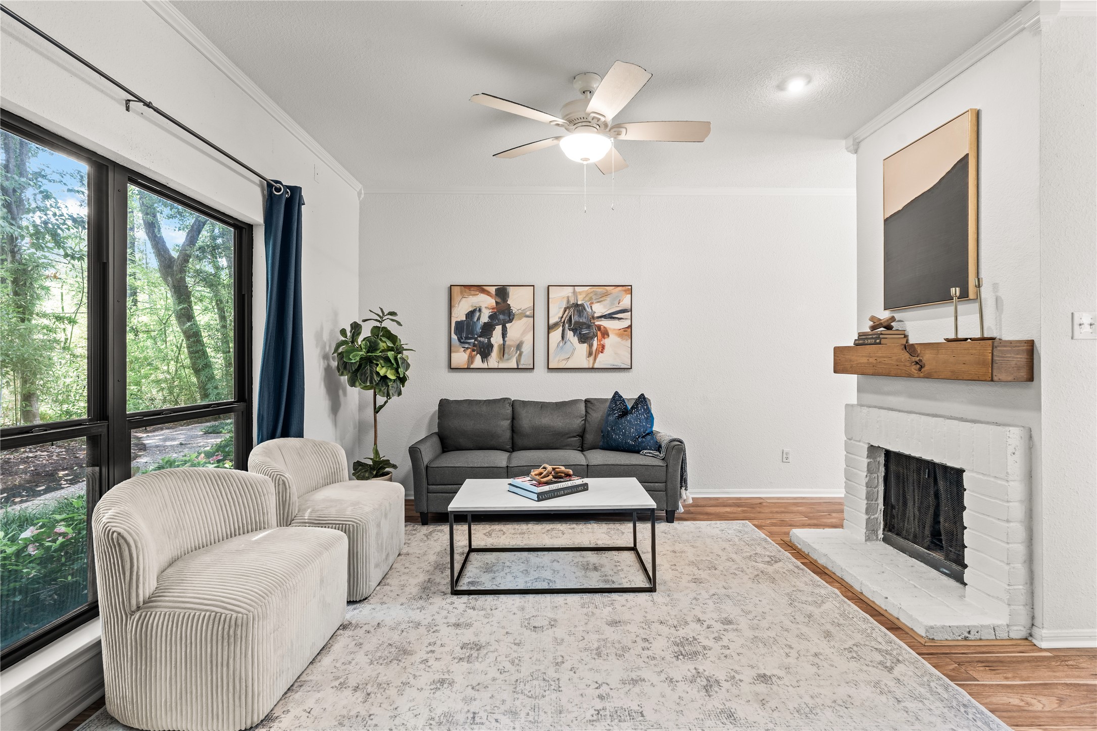 Oversized windows frame the mature trees just outside, bringing in natural light while creating a peaceful backdrop to the main living area.