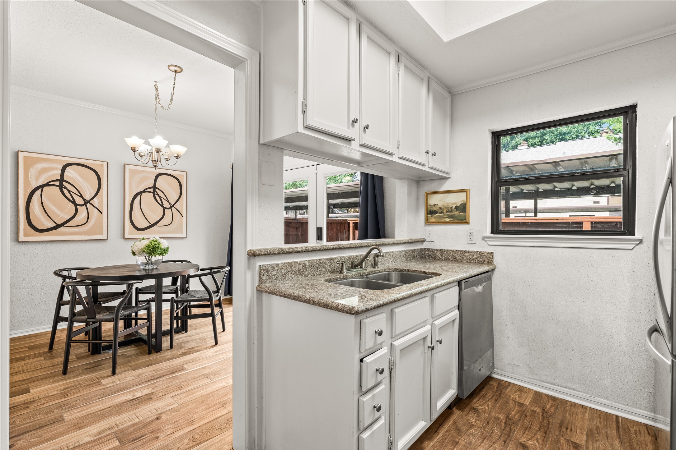 A functional kitchen with abundant upper cabinetry, stainless steel appliances, and an open pass-through that keeps the space feeling bright and connected.