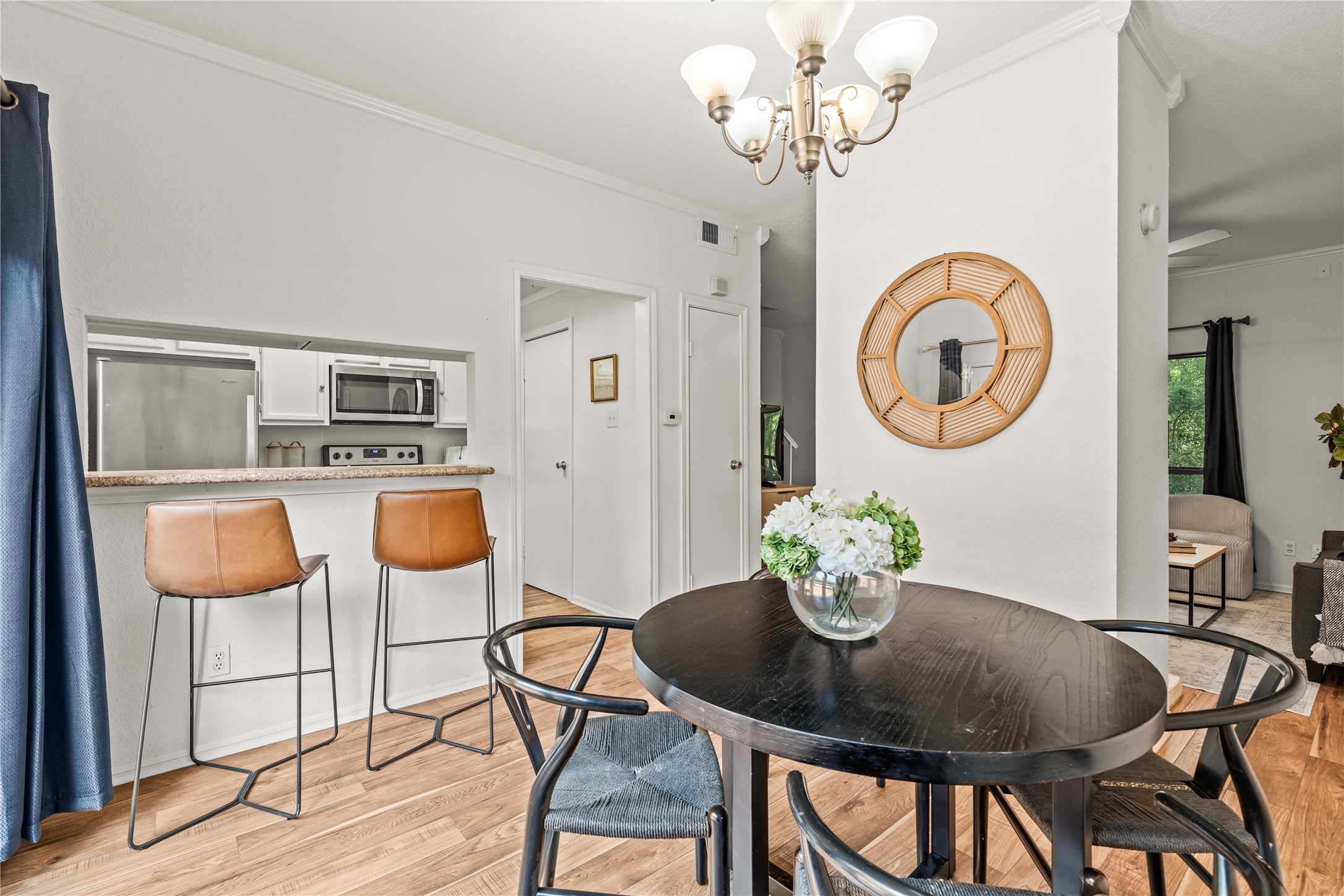 A pass-through breakfast bar keeps the kitchen connected to the dining area, making everyday meals and casual conversations feel effortless.