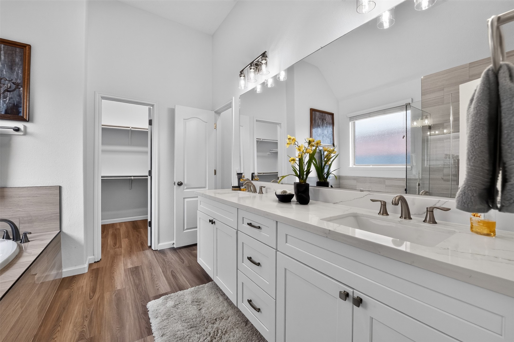 The primary bathroom has new Quartz countertops with dual undermount sinks. New cabinets and vanity lighting too.
