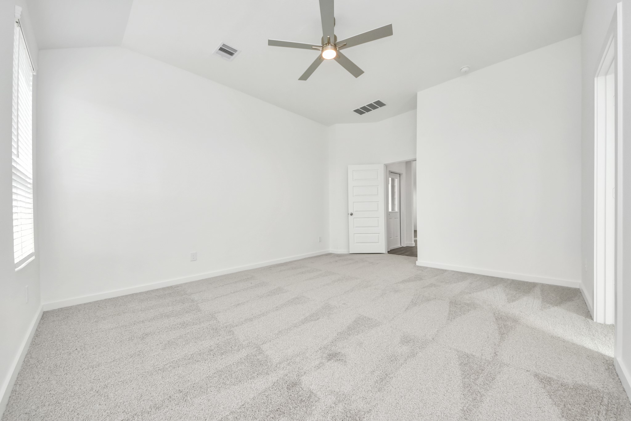 Escape to tranquility in this spacious primary room, adorned with plush carpeting and bathed in the soothing hues of warm paint colors, creating a cozy retreat for relaxation. Sample photo of completed home with similar floor plan. Actual colors and selections may vary.