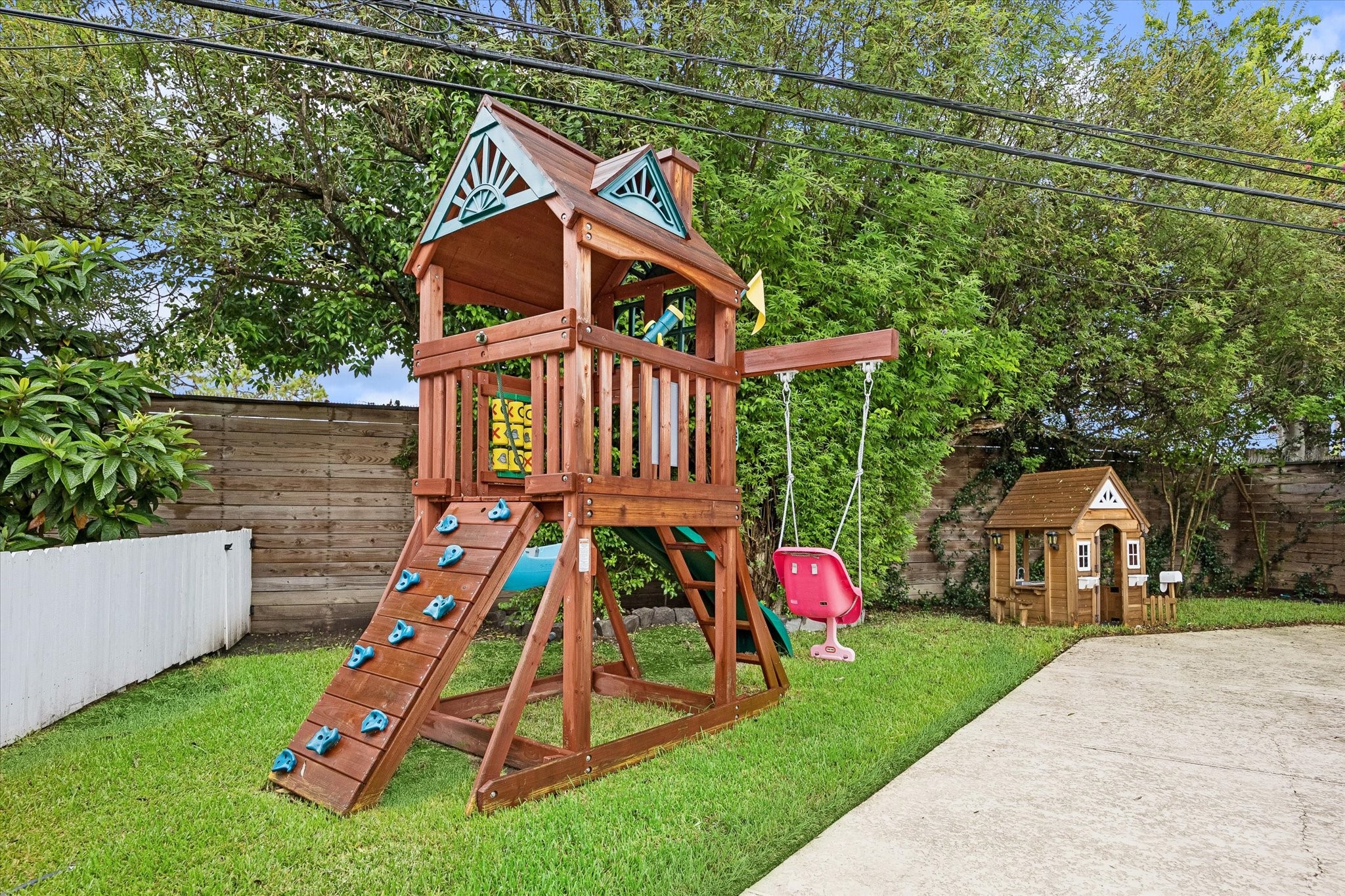 A private play area sits just beyond the pool's
safety fencing, offering peace of mind alongside
outdoor enjoyment. The thoughtfully zoned
backyard accommodates both relaxation and
recreation. Play set and doll house included with
the listing.