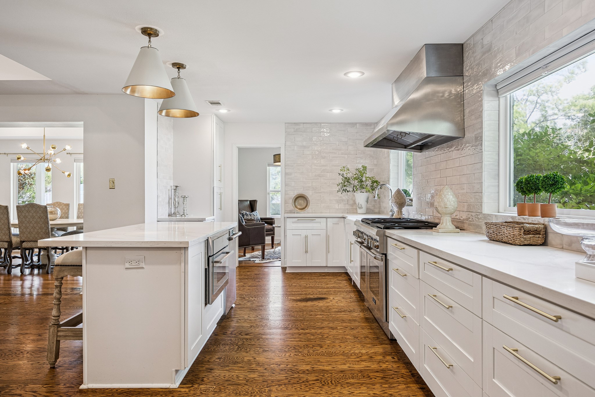 (25x10) This kitchen features a spacious island finished in quartz countertops, offering ample room for meal preparation and entertaining alike. The
stainless range and vent hood anchor the space
with a polished, well-appointed finish.