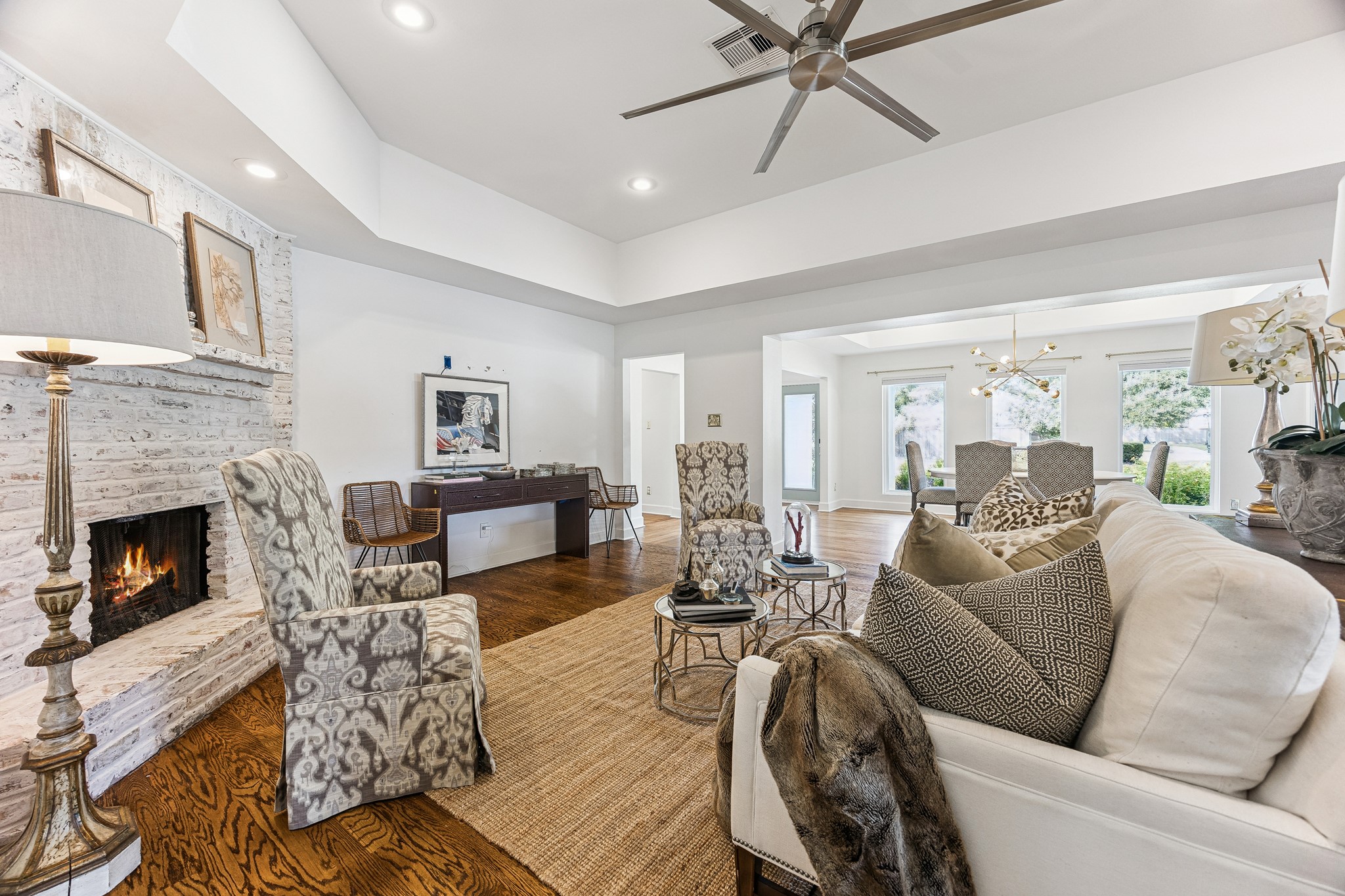 (20x16) There is nothing better than coming home to a crisp white painted home. The living room is grounded by a striking whitewashed brick fireplace, a natural focal point for the space. The open-concept design allows the dining and living rooms to connect seamlessly, ideal for both everyday living and entertaining. (Living Room television mount excluded)