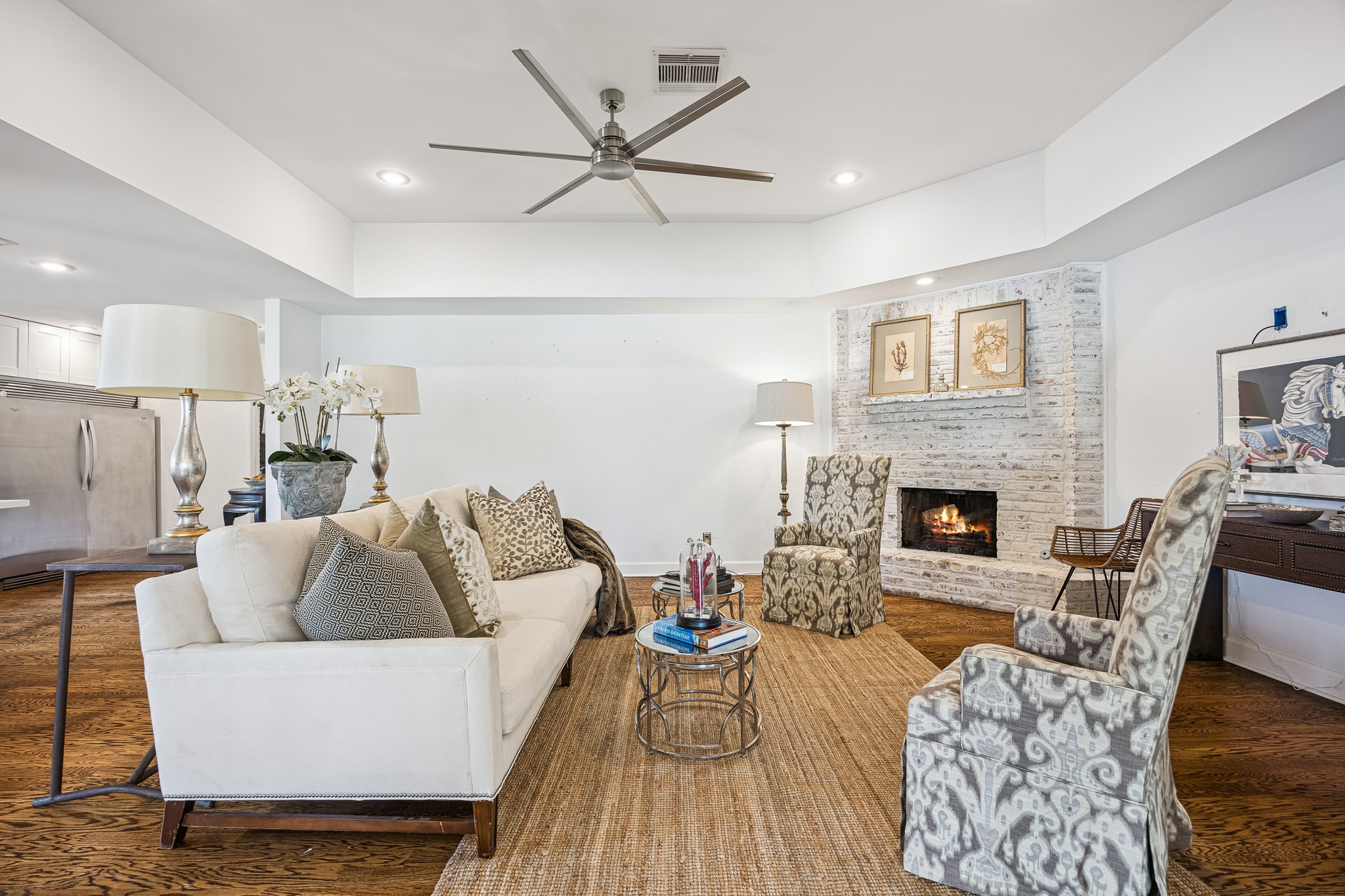 The heart of the home, this spacious family room blends warmth and functionality with a
whitewashed brick fireplace, hardwood floors, and soft neutral designer paint. Recessed lighting brightens the space, while the open floor plan keeps you connected to the kitchen and dining room. Perfect for relaxing evenings or hosting guests.
