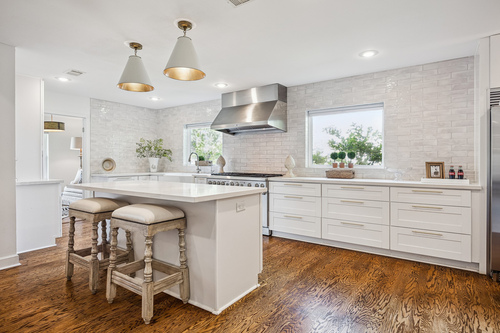(25x10) The chef's kitchen is defined by an
oversized island with breakfast bar seating, ideal for casual dining or entertaining. Designer pendant lighting and warm hardwood flooring complete this thoughtfully appointed space. Through the door on the left provides access to a study or breakfast room space!