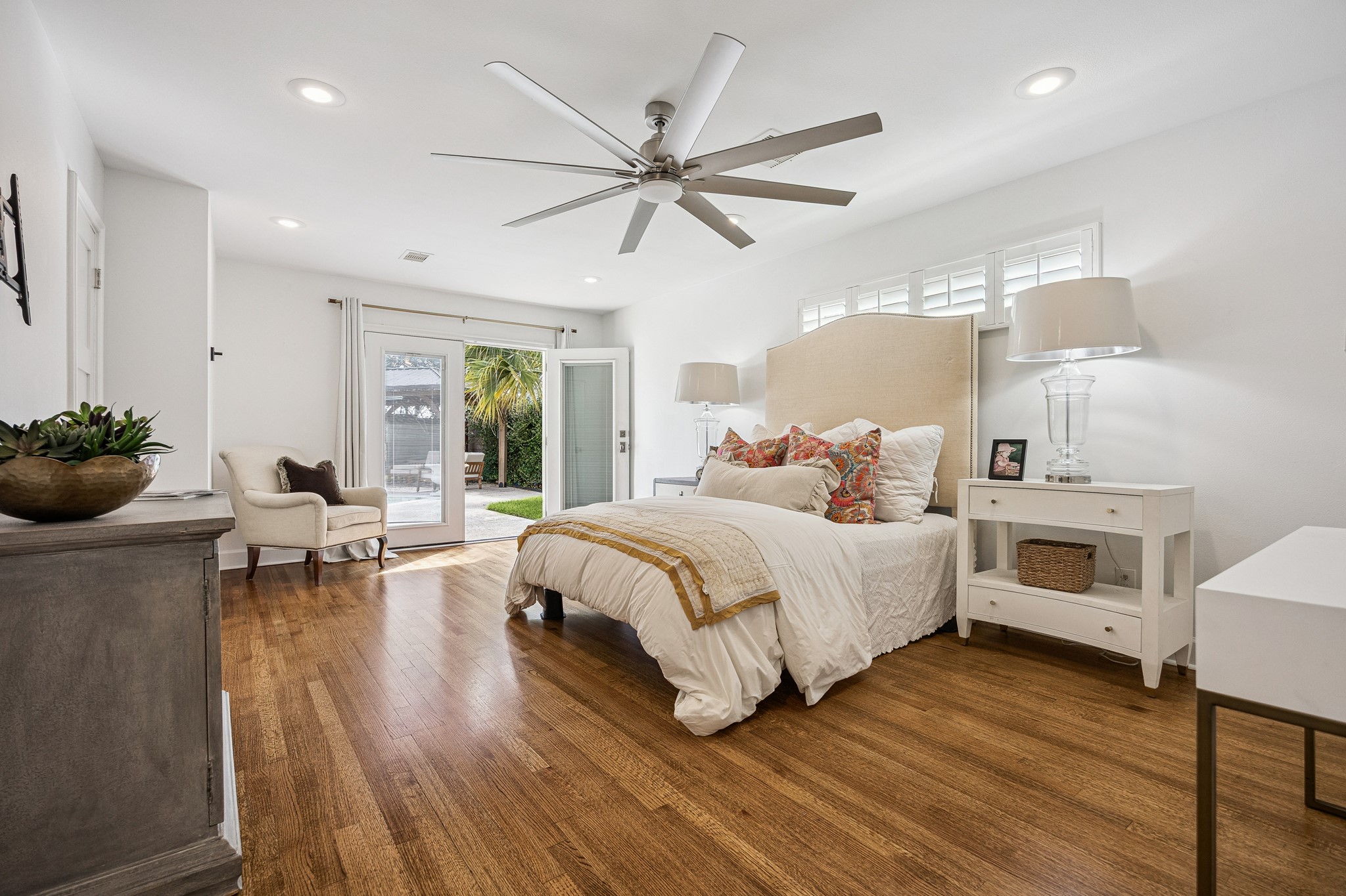 The spacious primary bedroom (22'x13') easily
accommodates a king-size bed with room to spare. Warm hardwood floors, a designer ceiling fan, and access to the backyard create a comfortable retreat
for everyday living.