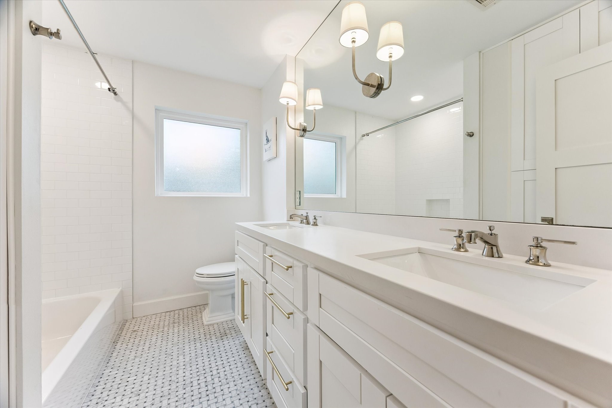 This bath is finished with a tub-shower combination
and mosaic tile flooring, balancing classic style with
everyday function. The refined finishes carry the
home's design sensibility into every corner.