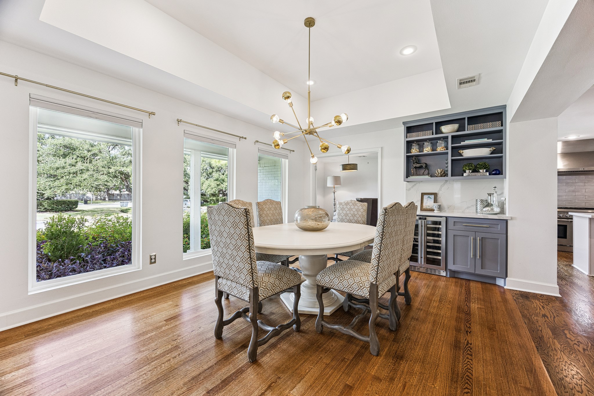 Enjoy views of the lush front landscaping through oversized windows in this light-filled dining space. A built-in beverage station with a wine refrigerator adds convenience when entertaining.