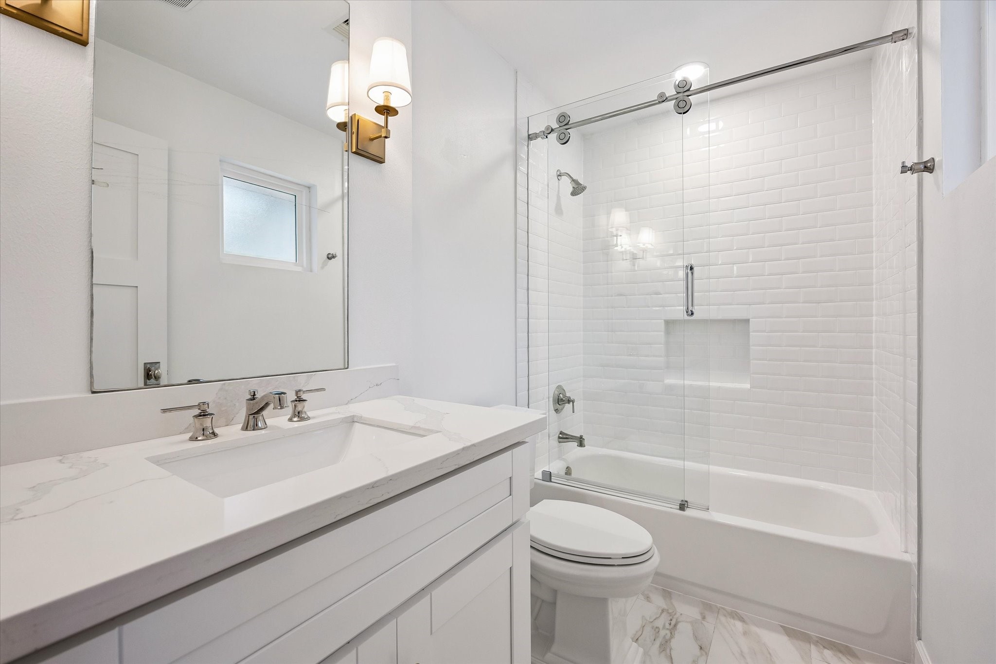 Subway tile surrounds the tub-shower combination
in this well-appointed bath, paired with a single
vanity for everyday ease. The clean, classic finishes
offer timeless appeal.