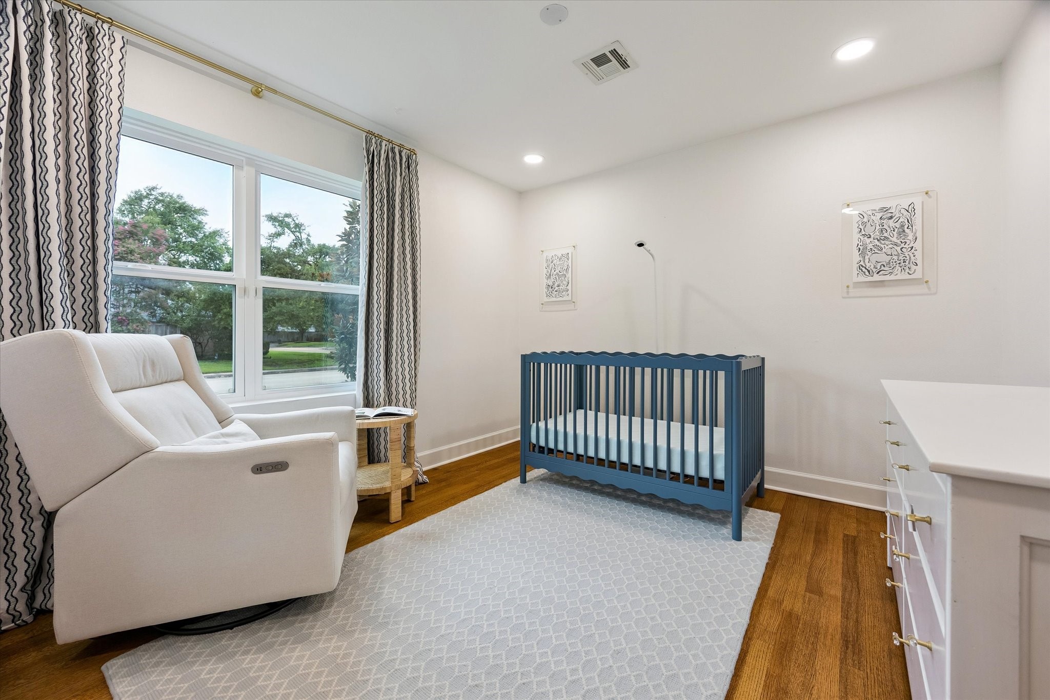 (12x12) A picture window fills this guest bedroom
with abundant natural light, creating a soft,
welcoming atmosphere. The thoughtful layout
offers a serene space designed for comfort.
(Draperies and rods excluded)
