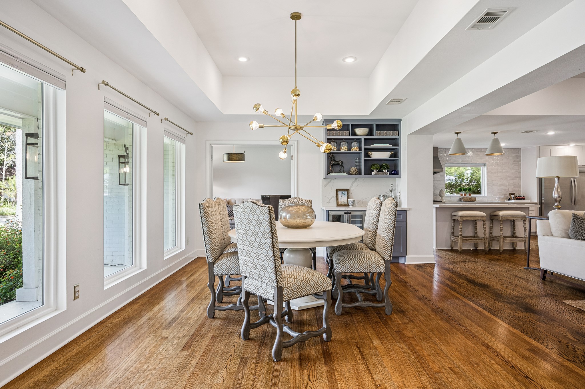 (15x12) Beneath a tray ceiling, this ready to
entertain dining area with dry bar to showcase
glassware and mini refrigerator opens effortlessly toward a set of French doors leading to the adjacent study or breakfast room. This thoughtful connection creates a versatile flow between formal dining and a quiet home office.