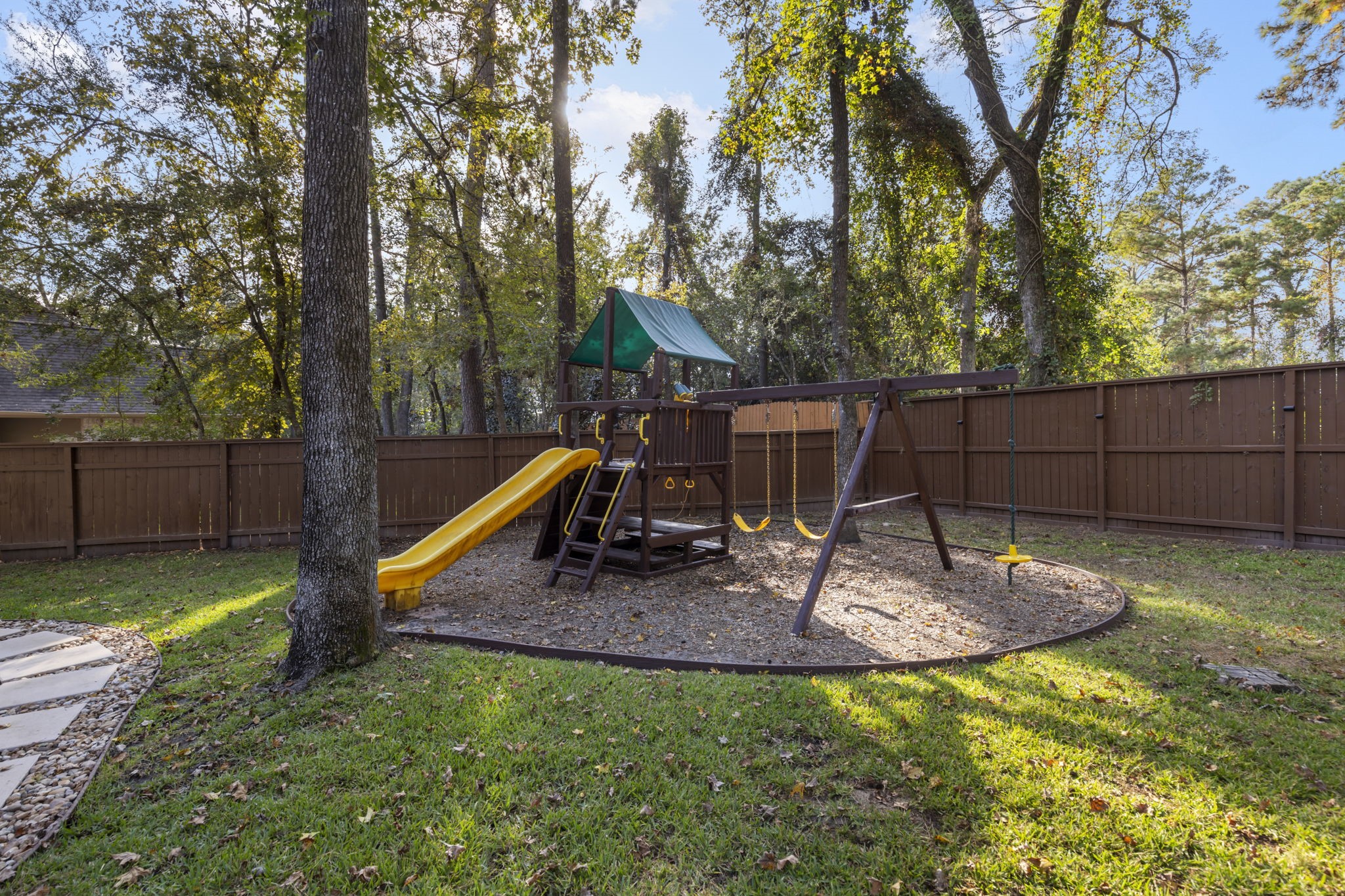 This backyard escape features newly refurbished kids' play equipment, making it a delightful space for everyone to enjoy!