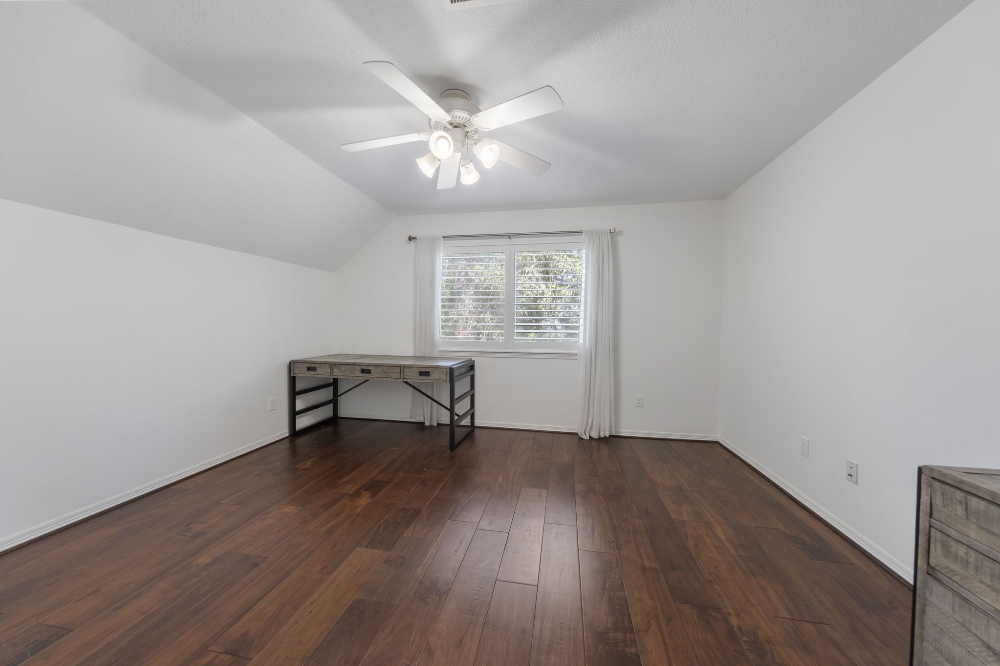 Bright and airy upstairs bedroom boasts gleaming wood floors, ample natural light, and walk-in closet.