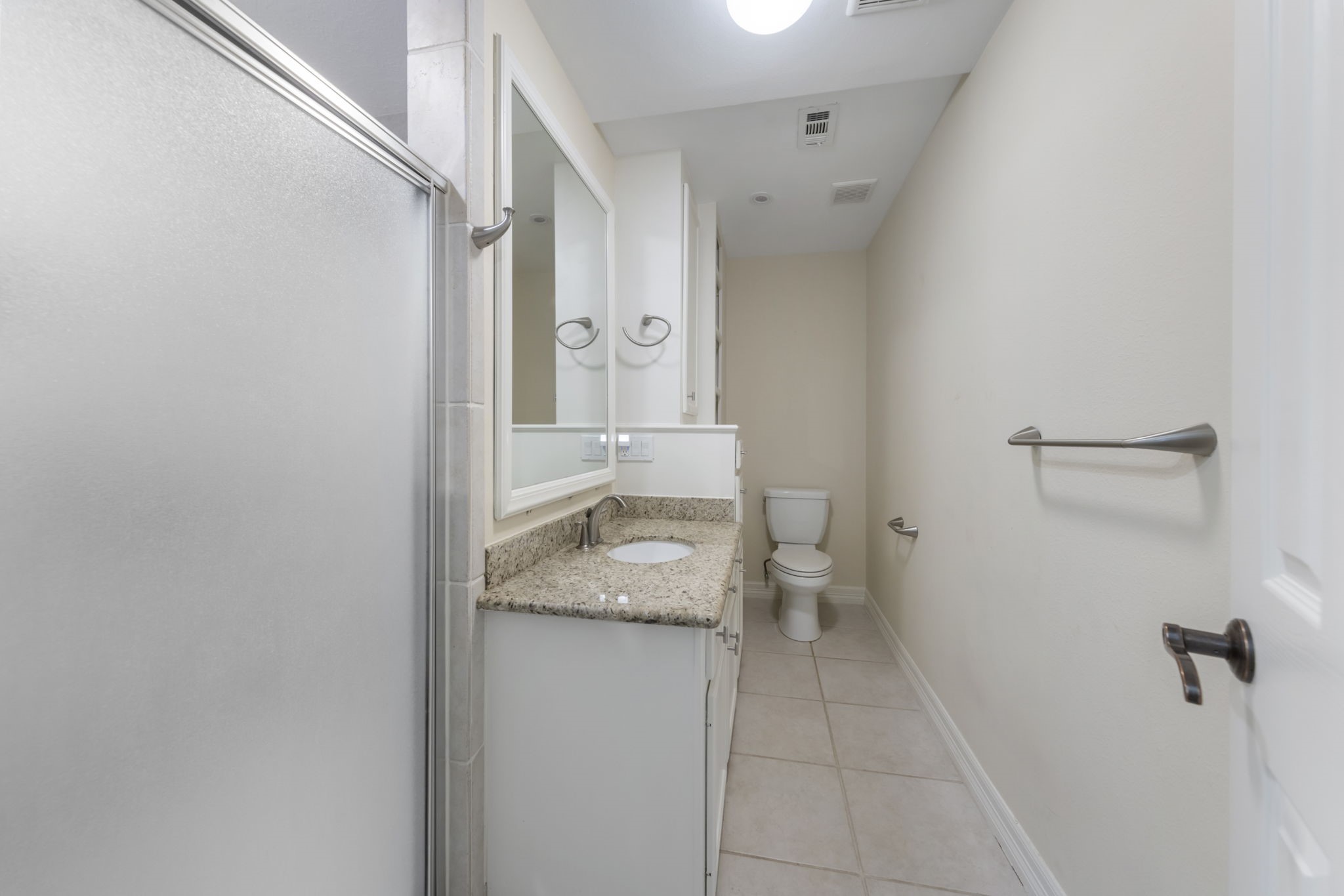 Ensuite bath provides stand up shower, ample storage, and timeless granite countertops.