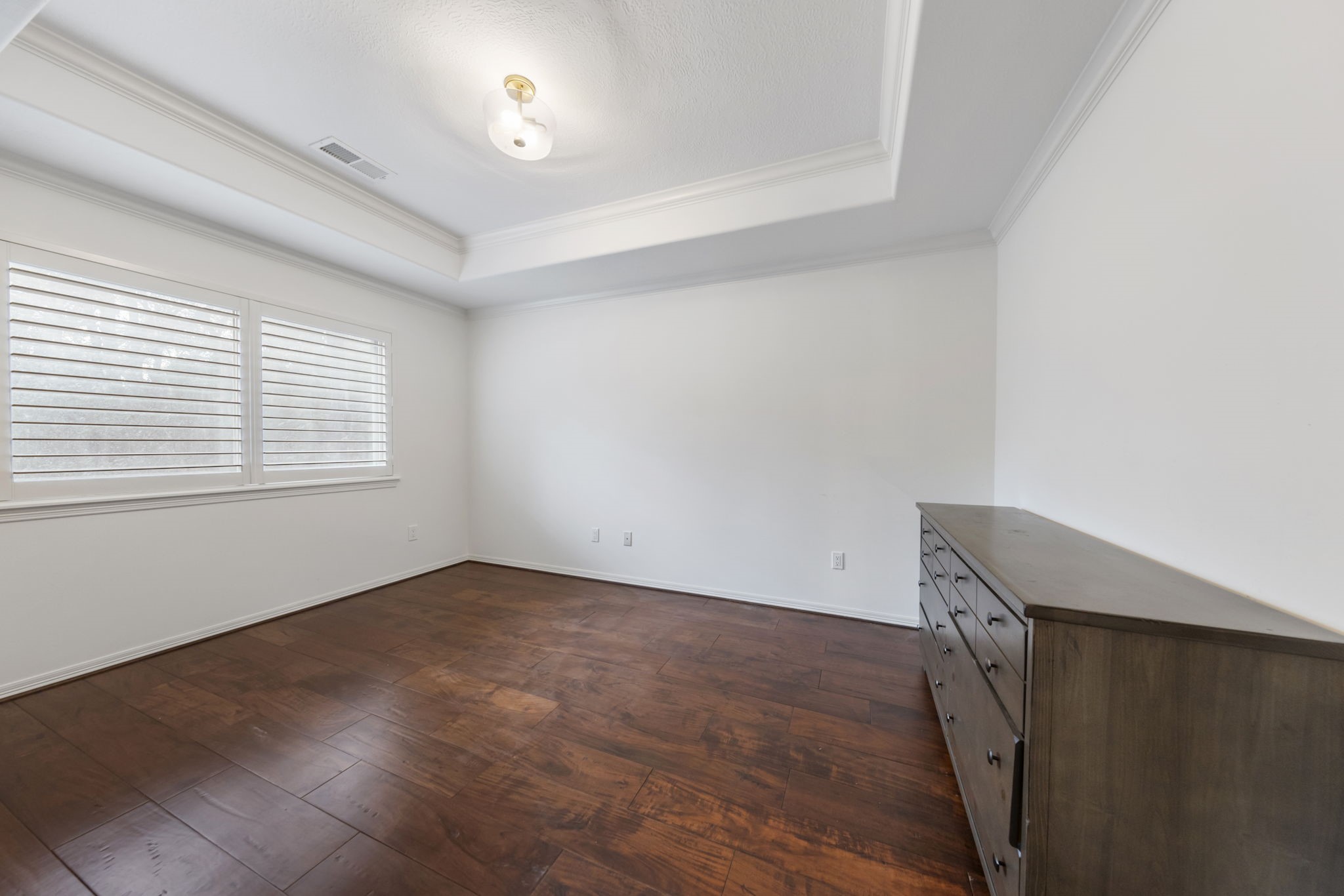 At the top of the back staircase, this bedroom features a tray ceiling, beautiful wood floors, abundant natural light, and a spacious walk-in closet.