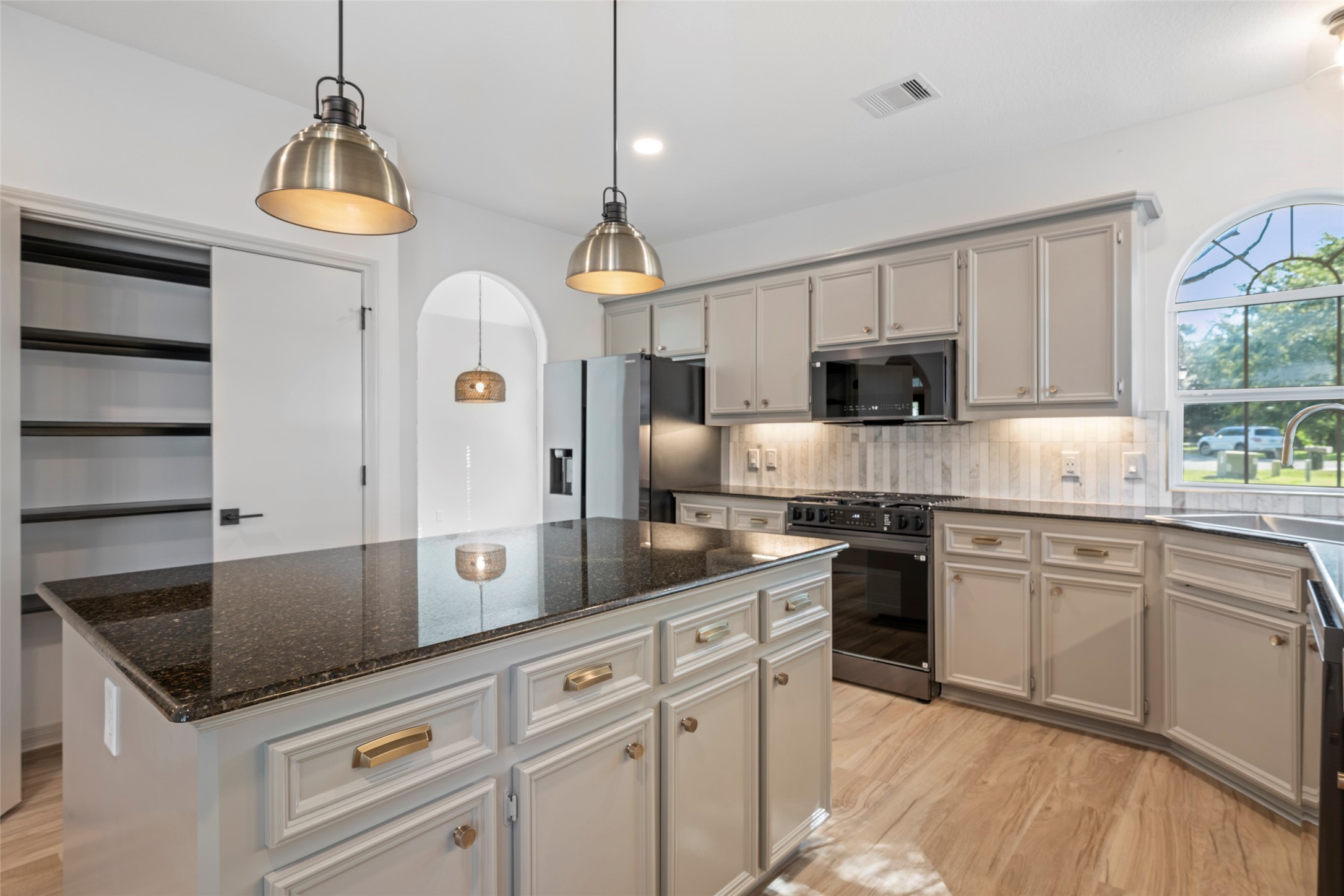 Sleek granite counters, brand new appliances and designer light fixtures