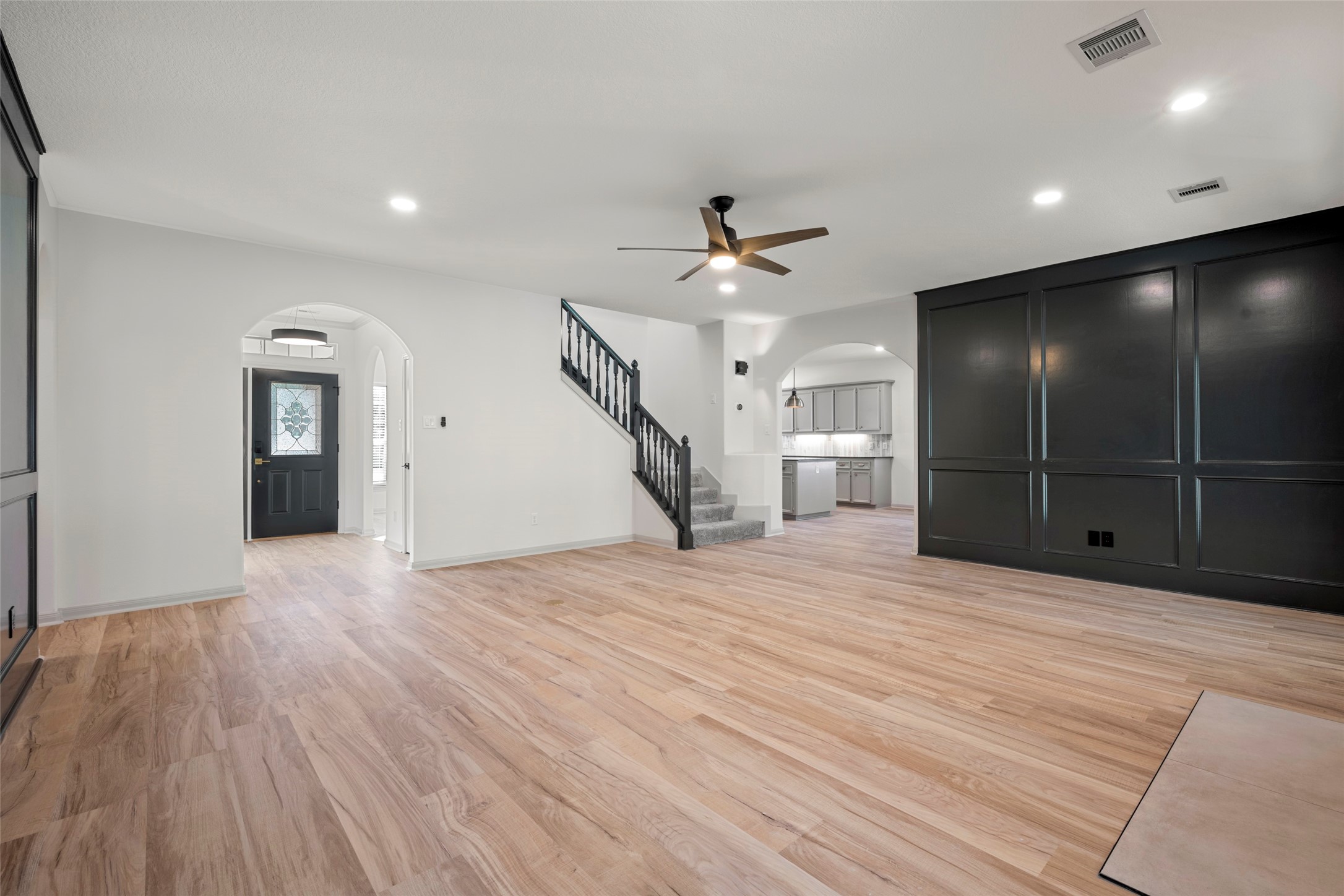 Living room features wall paneling, a fireplace and double doors to patio
