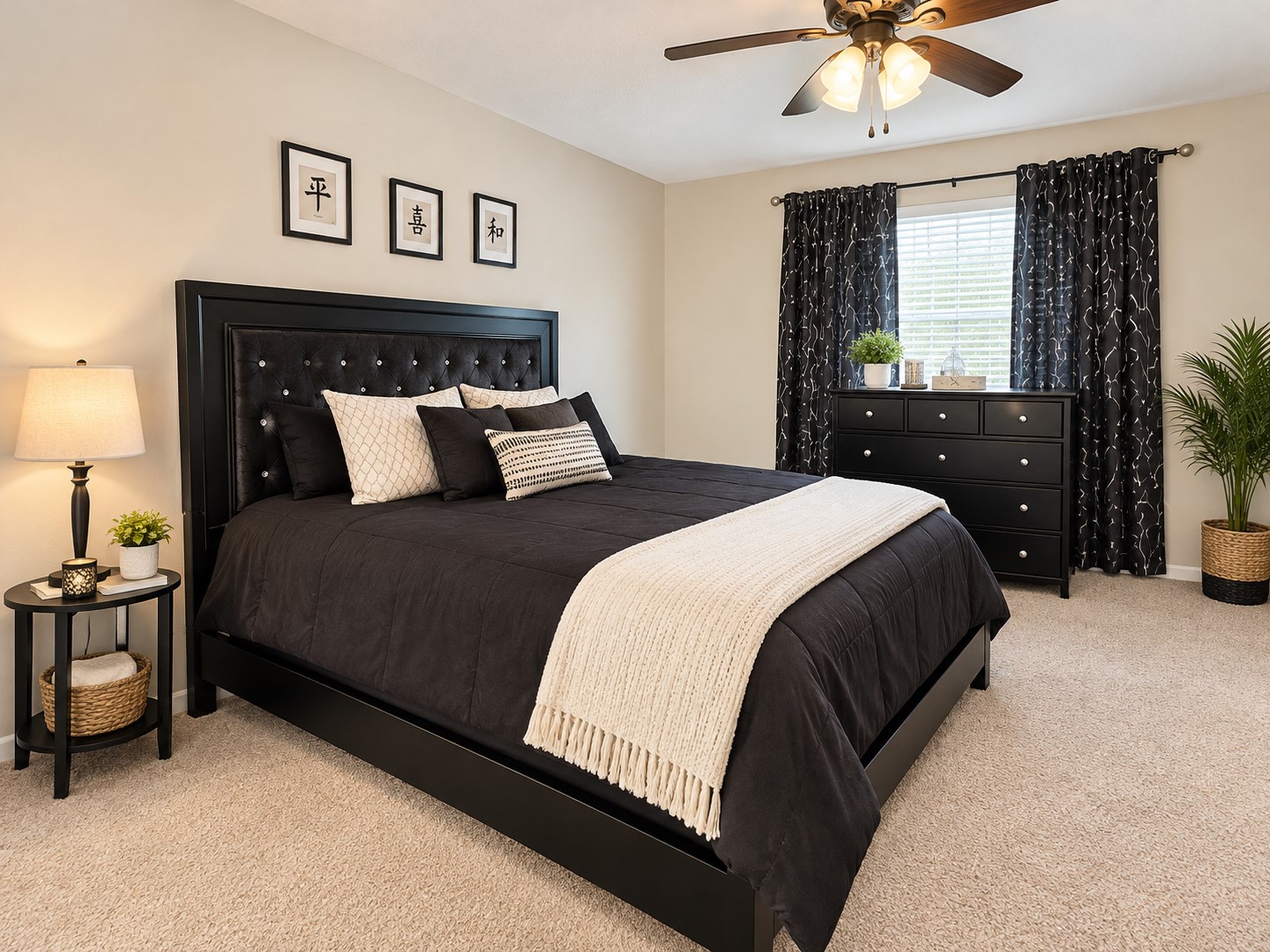 Elegant bedroom featuring a plush black bed with stylish pillows, complemented by a sleek dresser and charming decor.