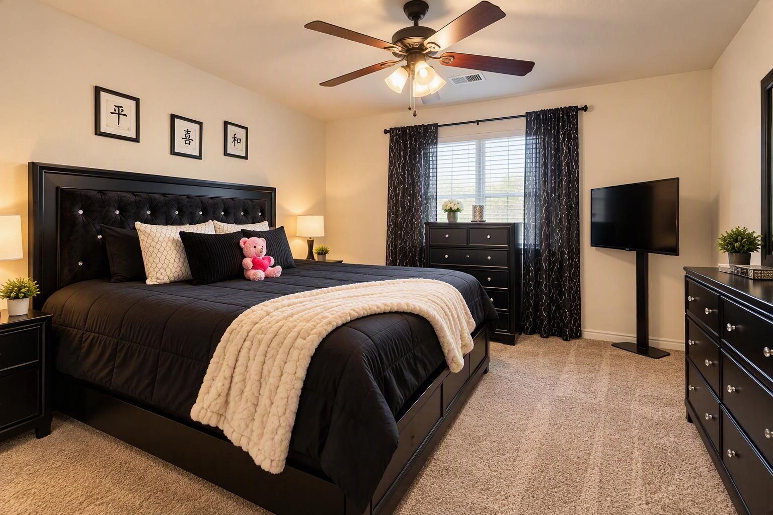 Chic bedroom featuring a plush king-sized bed with elegant black furnishings, cozy carpeting, and a ceiling fan for comfort.
