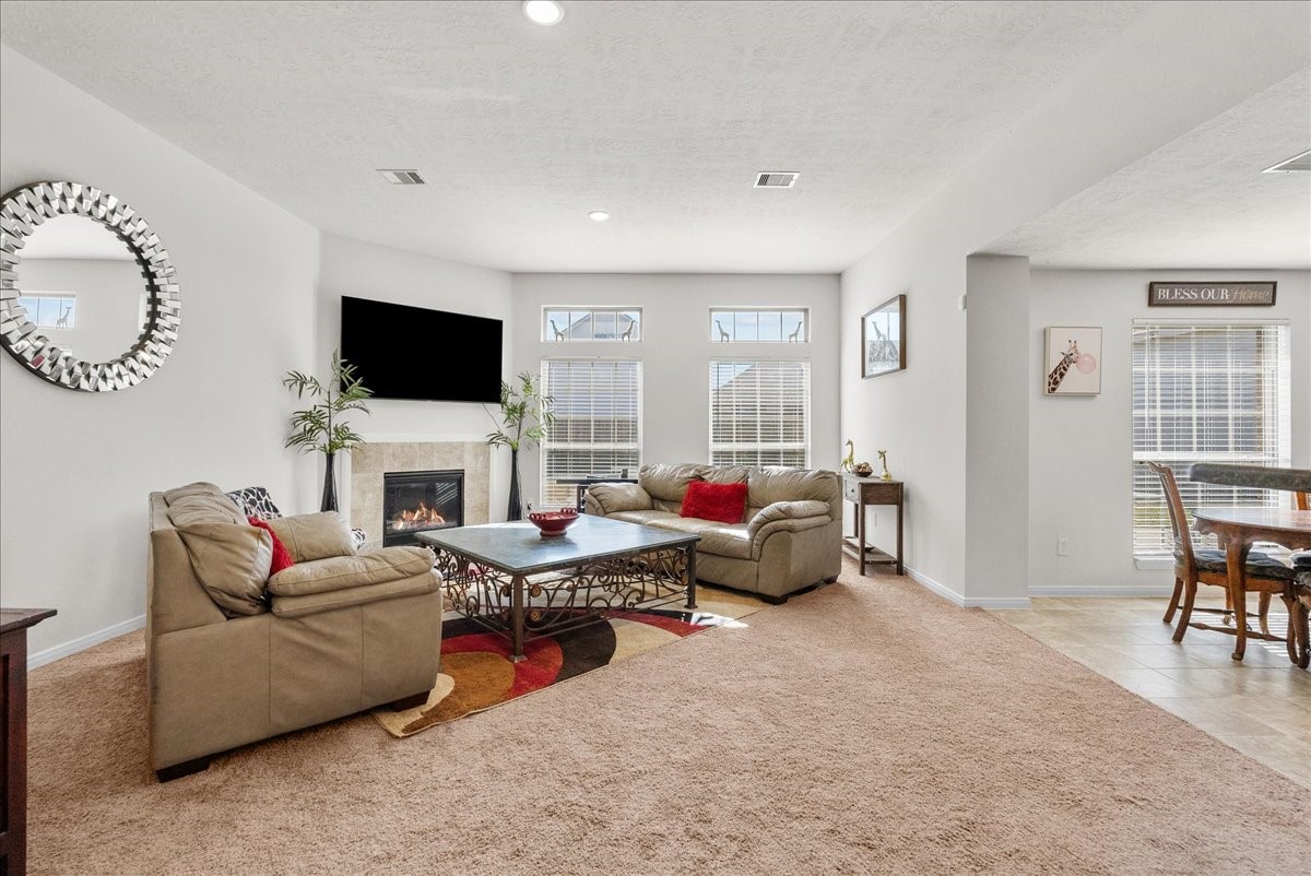 The living room features a cozy fireplace and is bathed in natural morning light through an abundance of windows