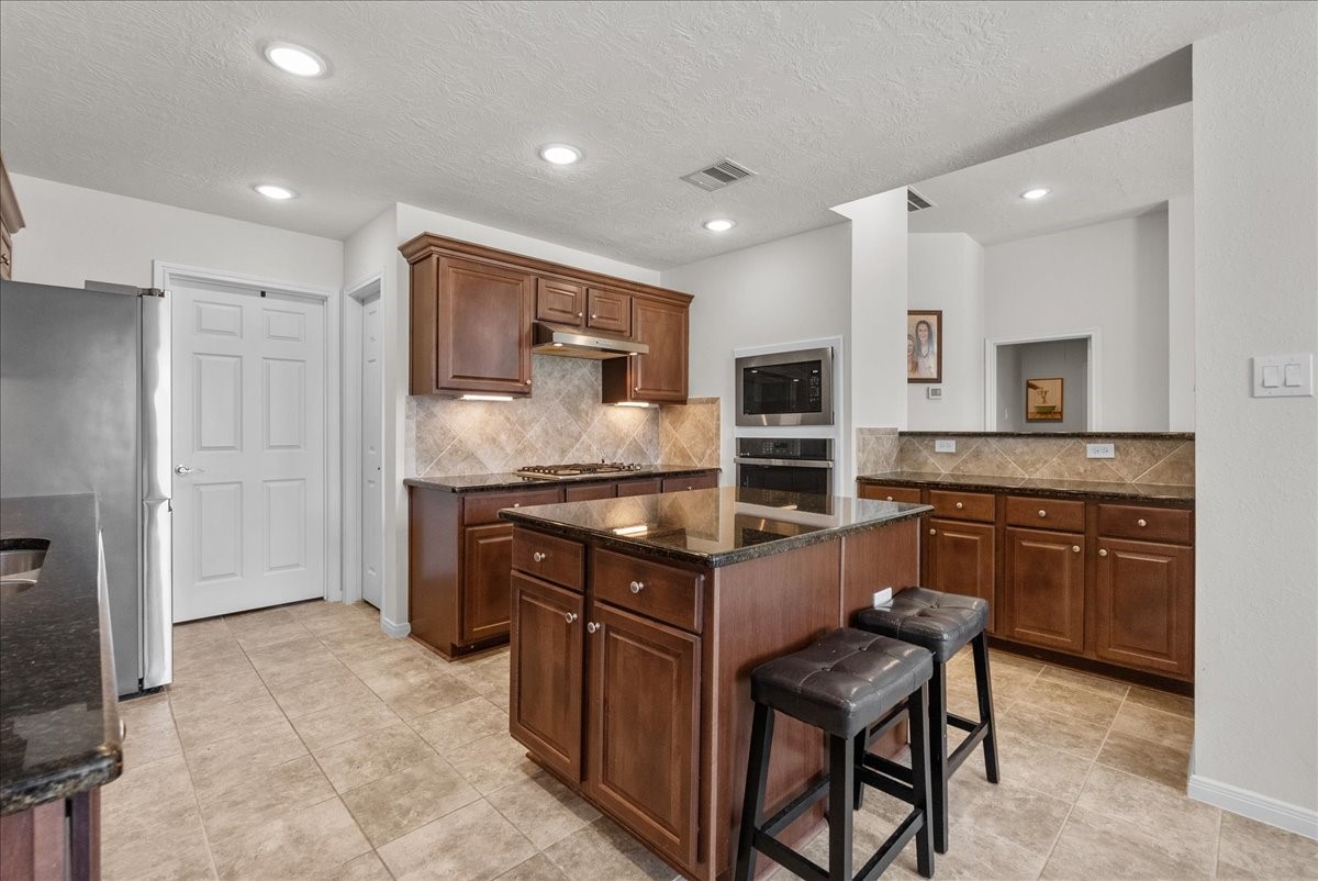 Chef's eat-in island kitchen features 42" cabinets with crown molding, granite countertops, stainless steel appliances and a breakfast bar