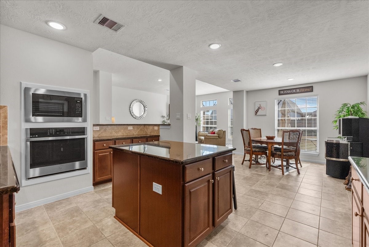 Chef's eat-in island kitchen features 42" cabinets with crown molding, granite countertops, stainless steel appliances and a breakfast bar