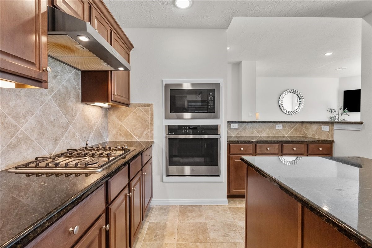 Chef's eat-in island kitchen features 42" cabinets with crown molding, granite countertops, stainless steel appliances and a breakfast bar