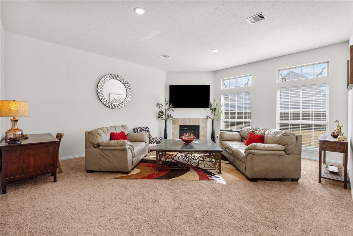 The living room features a cozy fireplace and is bathed in natural morning light through an abundance of windows