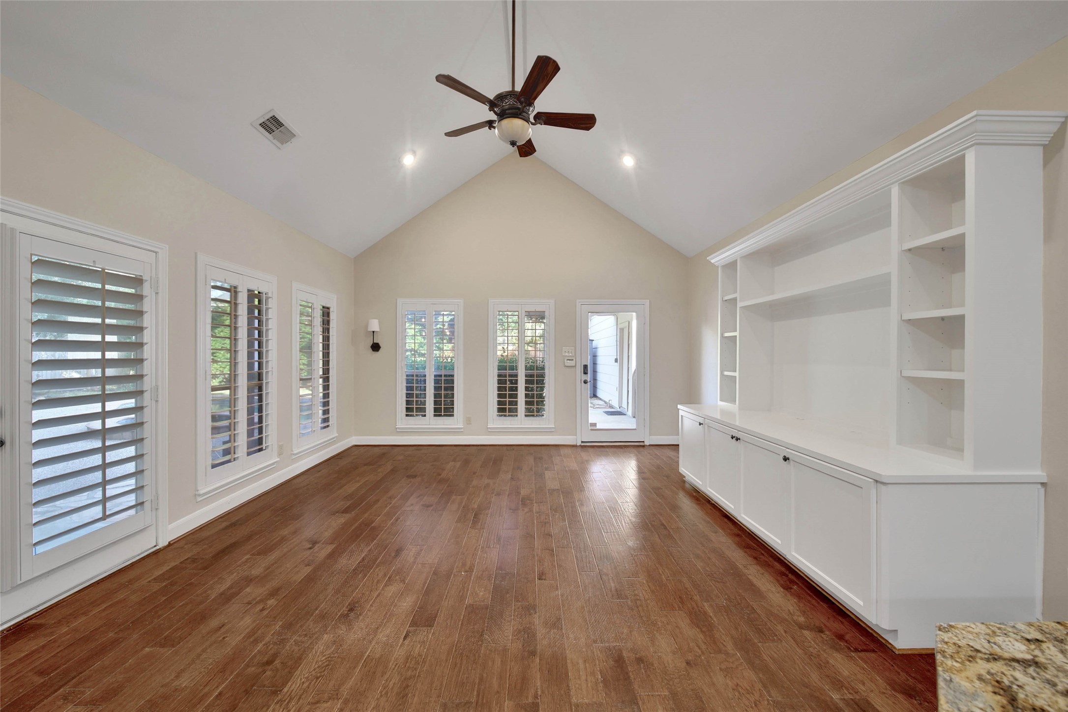 The den is located off the kitchen and has a large built-in for your entertaining needs. bright windows of the pool, patio and backyard surround this room. Vaulted ceiling adds to the spacious feel.