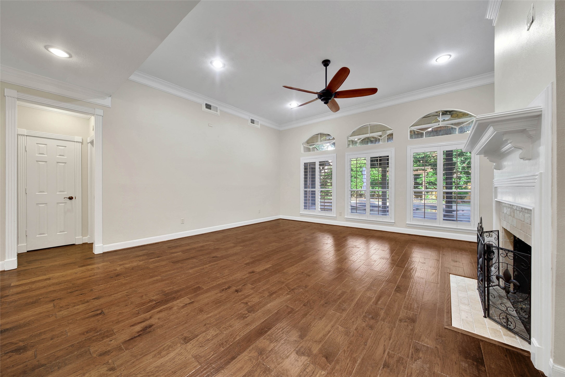 This outstanding living room showcases the beautiful hardwood floors. High ceilings, large windows overlooking the patio and pool, plantation shutters, recessed lighting and gaslog fireplace make this a comfortable place to relax or entertain. This outstanding living room showcases the beautiful hardwood floors. High ceilings, large windows overlooking the patio and pool, plantation shutters, recessed lighting and gaslog fireplace make this a comfortable place to relax or entertain.