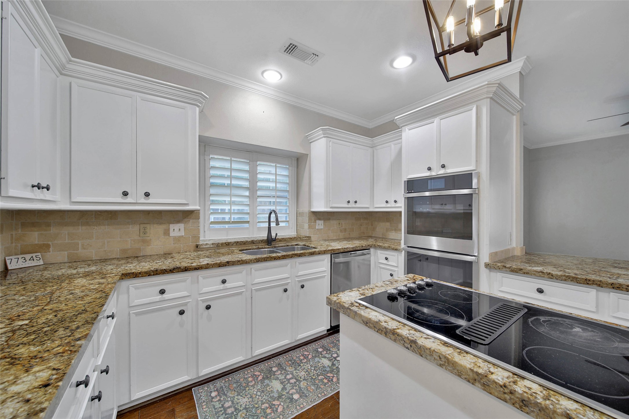 Kitchen appliances include GE Profile double wall ovens, downdraft island cooktop and GE Profile dishwasher.
