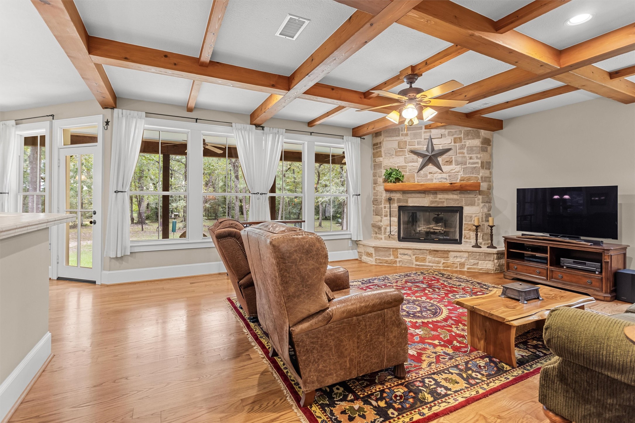 Beamed ceilings and a stone fireplace anchor the living room Beamed ceilings and a stone fireplace anchor the living room