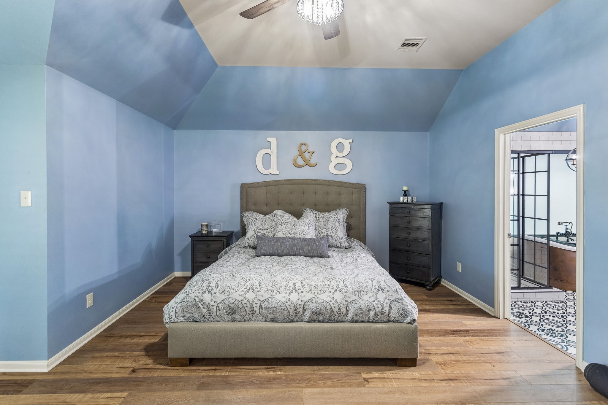 Spacious primary bedroom with high ceilings, and direct access to the en-suite bathroom.
