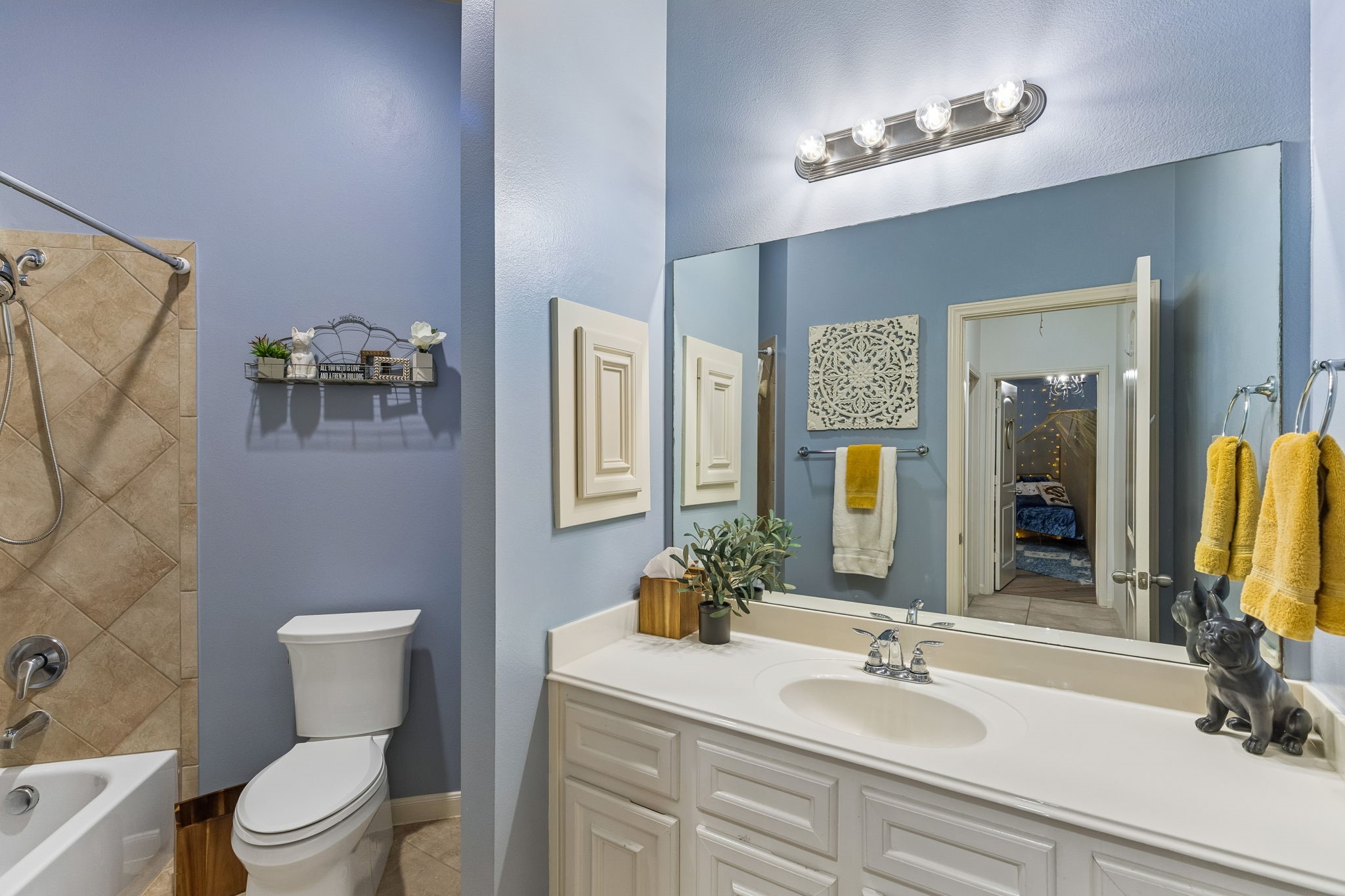 Full bathroom with vanity, tub/shower combination, and bright neutral finishes.