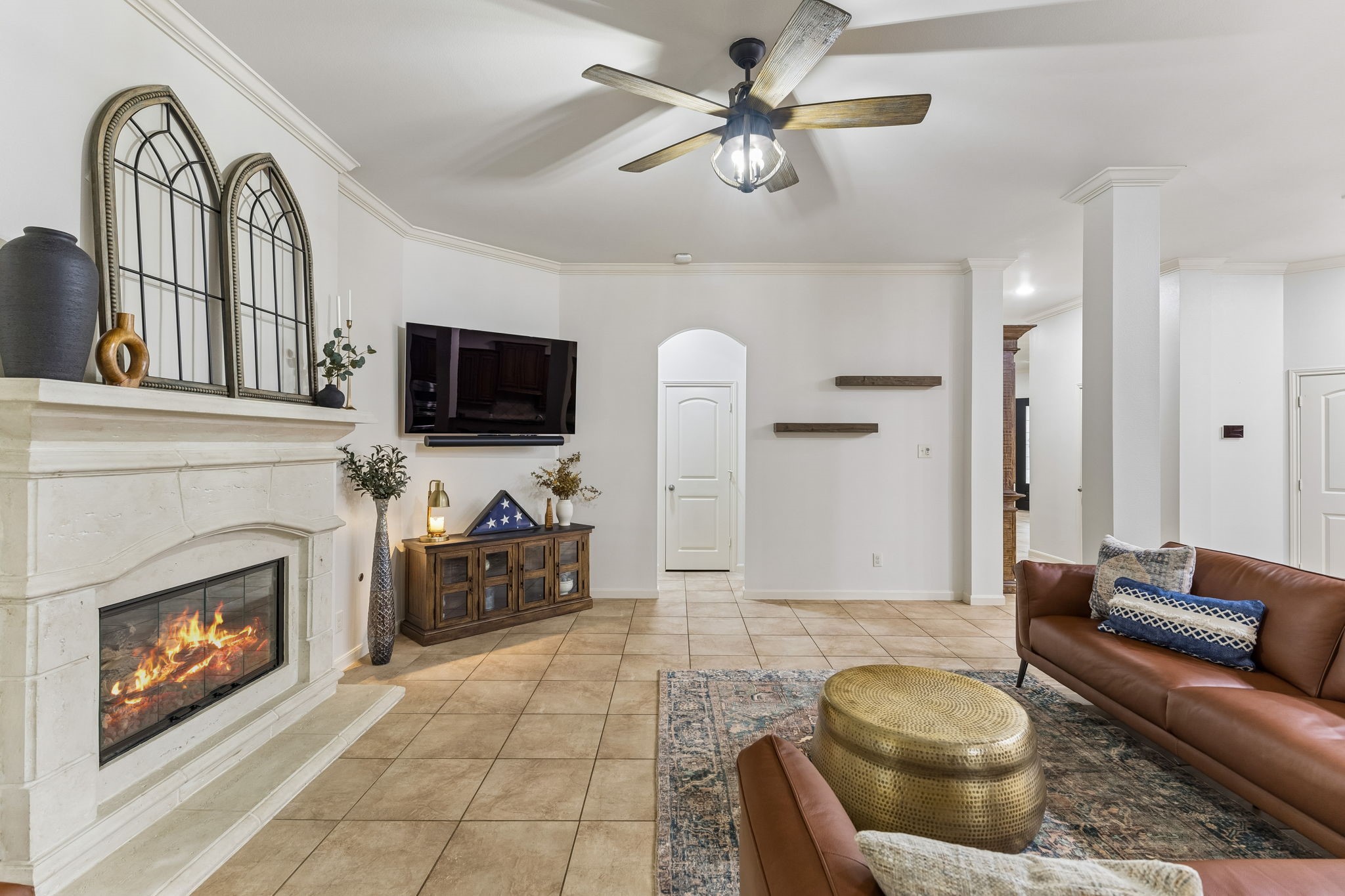 Inviting living area featuring a fireplace, ceiling fan, and an open flow to the surrounding living spaces. Inviting living area featuring a fireplace, ceiling fan, and an open flow to the surrounding living spaces.