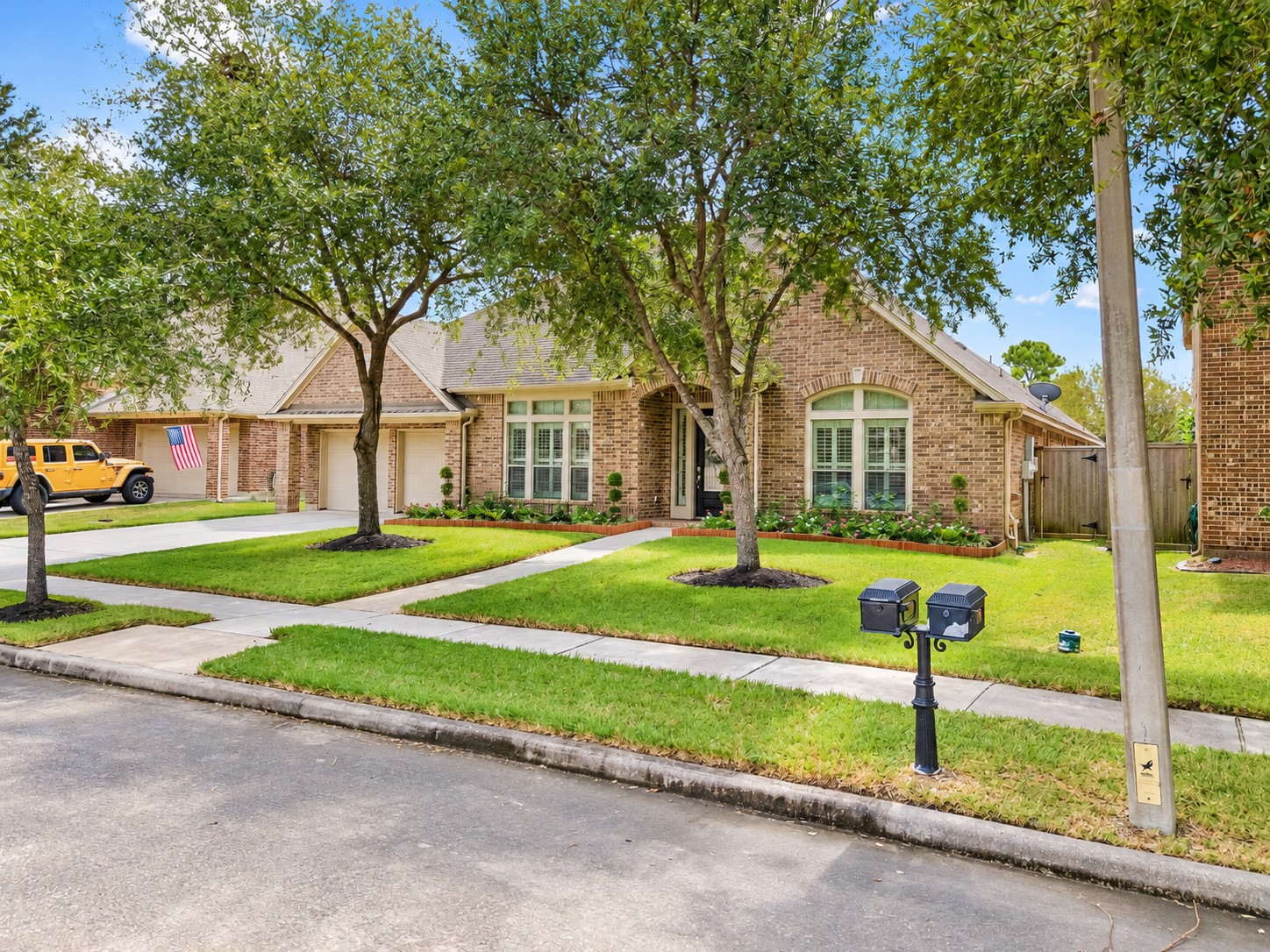 Wide street view of the home framed by mature trees and a spacious front lawn. Wide street view of the home framed by mature trees and a spacious front lawn.