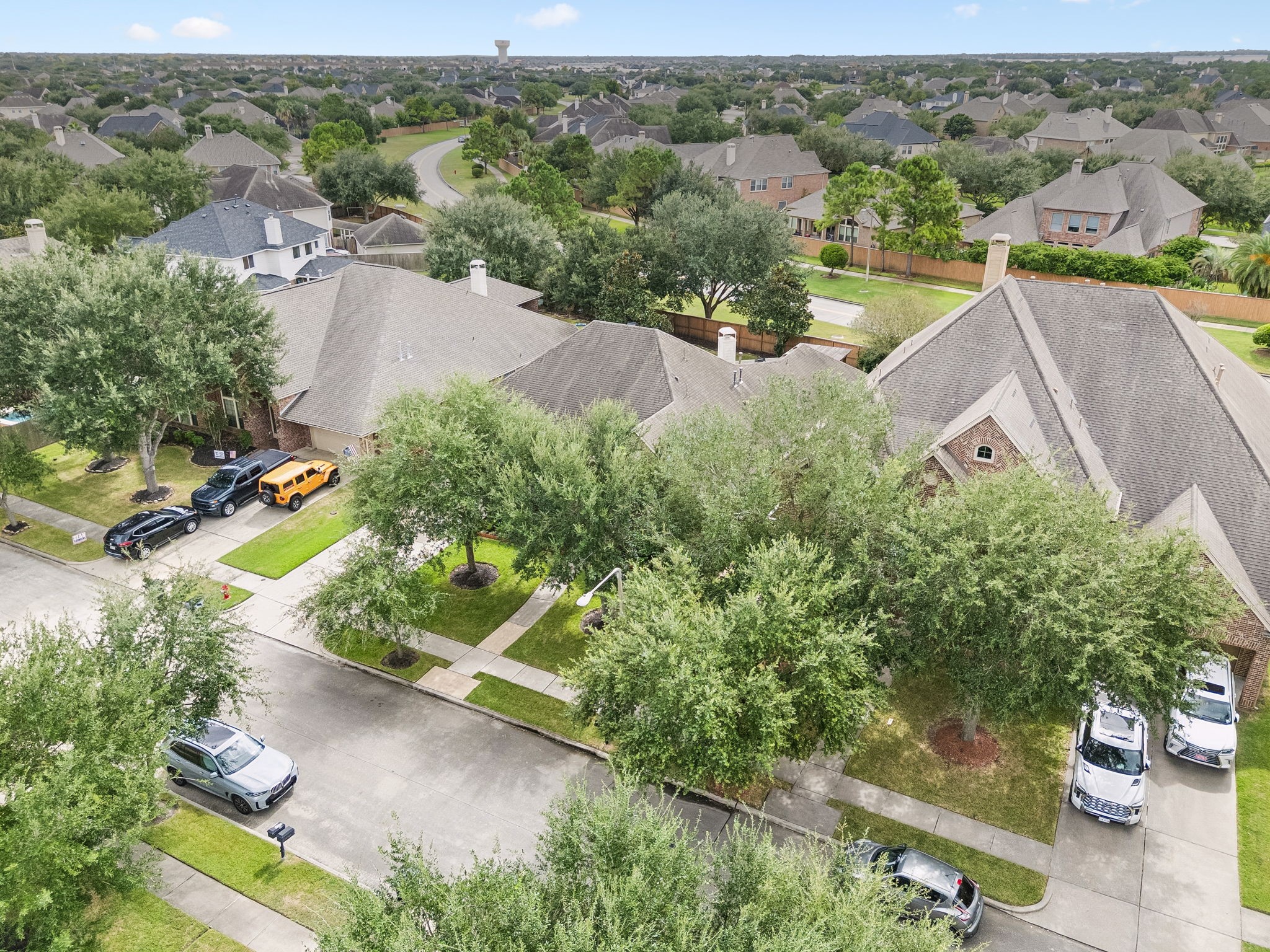 Aerial View  Aerial perspective highlighting the home, mature trees, surrounding residences, and neighborhood setting.