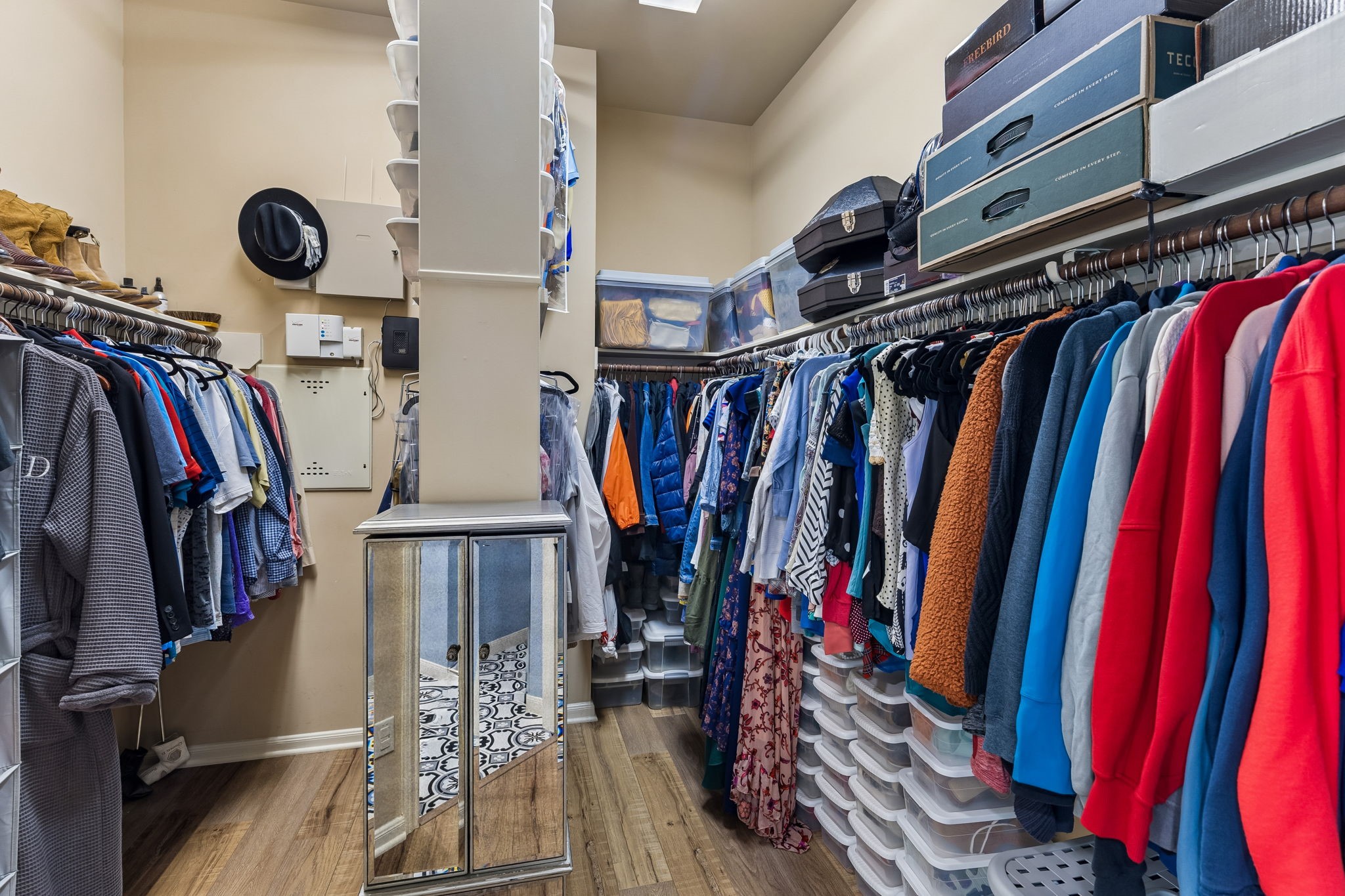 Spacious walk-in closet with built-in shelving and abundant hanging storage.