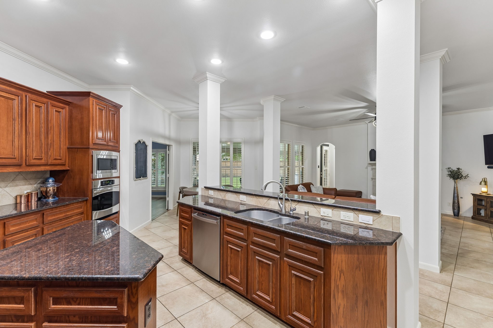 Spacious kitchen featuring rich wood cabinetry, granite countertops, recessed lighting, and a large center island.