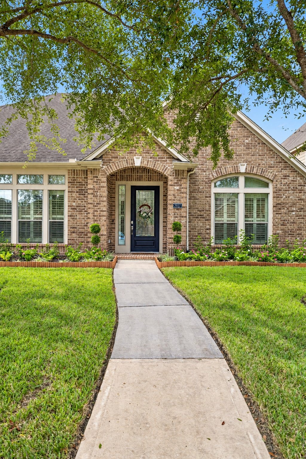 Front exterior view highlighting the landscaped walkway, mature trees, and inviting curb appeal. Front exterior view highlighting the landscaped walkway, mature trees, and inviting curb appeal.