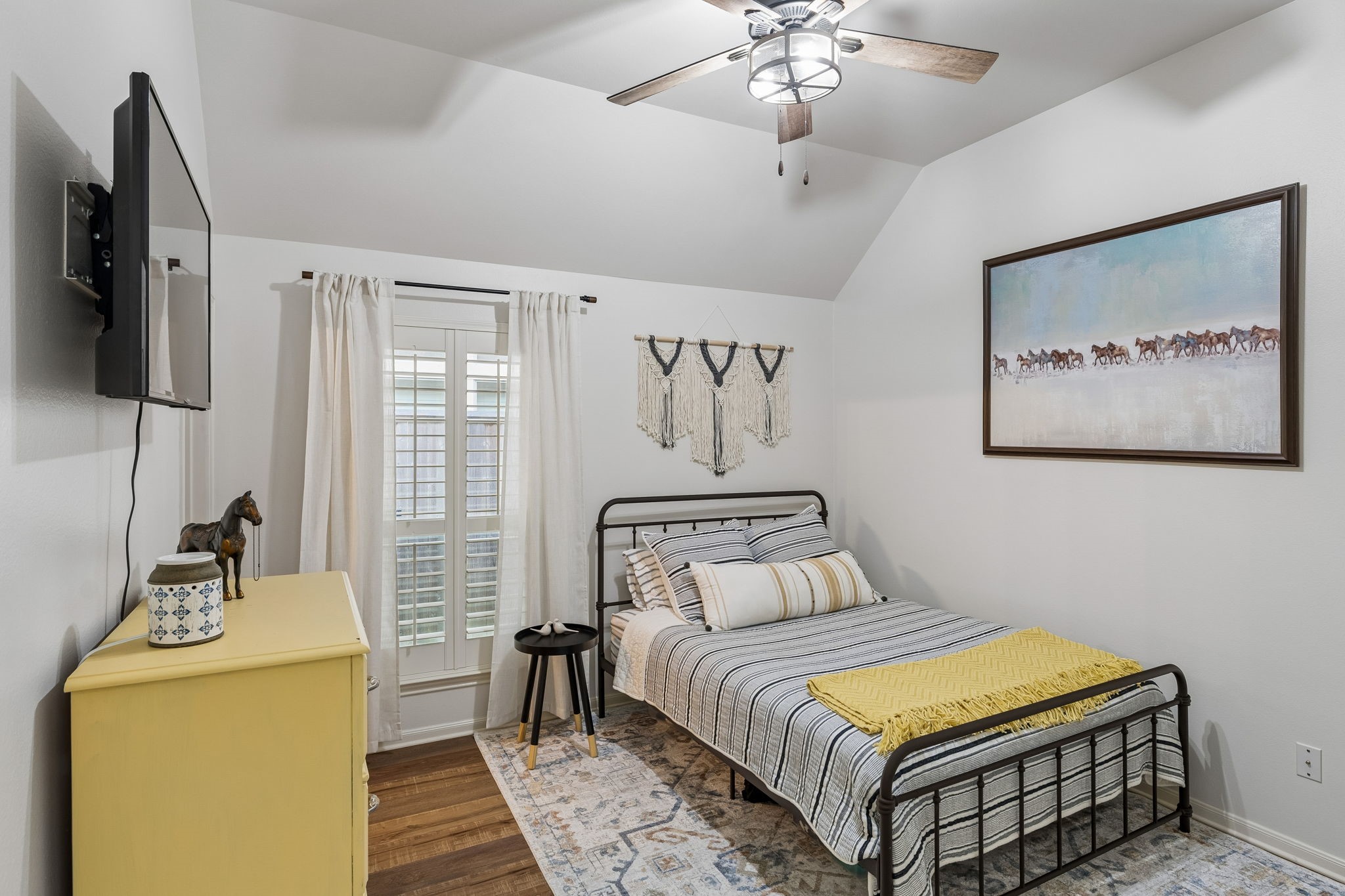 Comfortable bedroom with ceiling fan, natural light, and space for a full furniture arrangement.