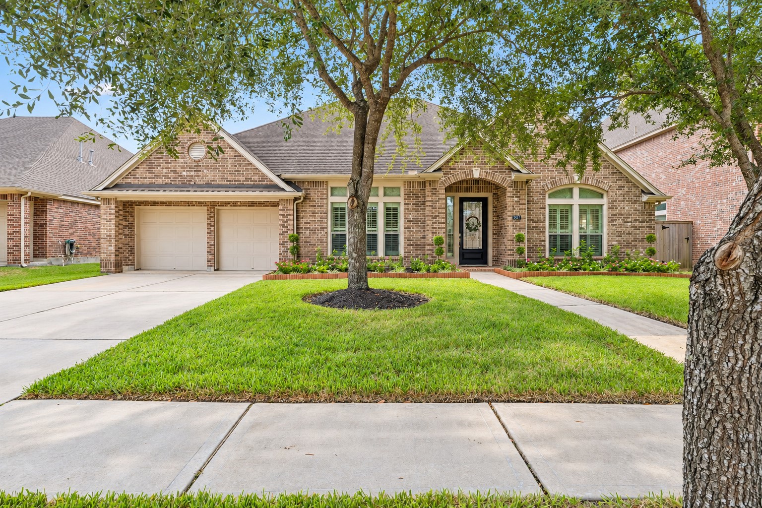 Attractive front exterior with mature trees, manicured lawn, and a welcoming entry.