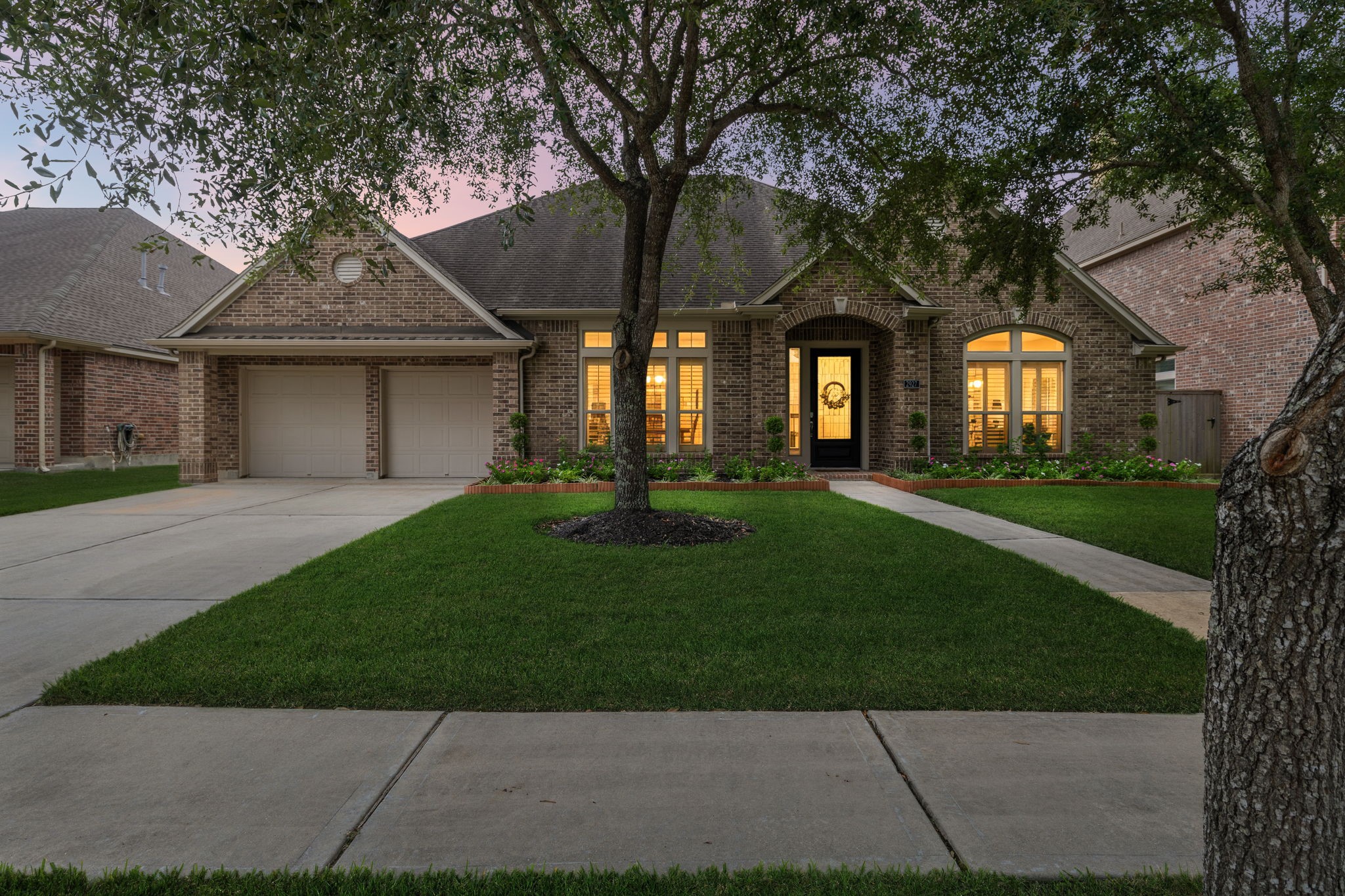 Evening exterior view showcasing the homes warm exterior lighting and inviting curb appeal. Evening exterior view showcasing the homes warm exterior lighting and inviting curb appeal.