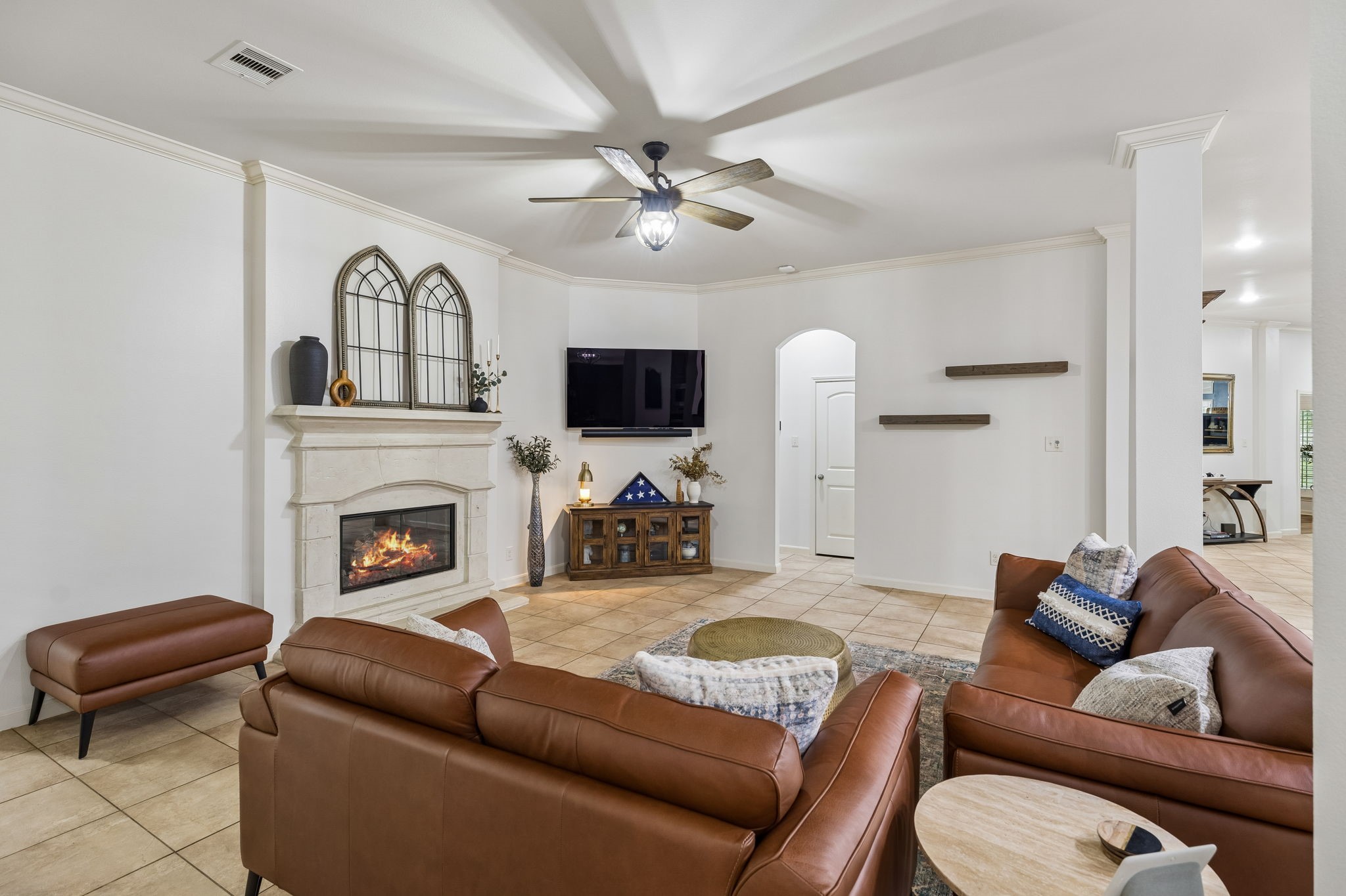 Alternate view of the living room highlighting the fireplace, generous seating area, and flow to adjacent spaces.