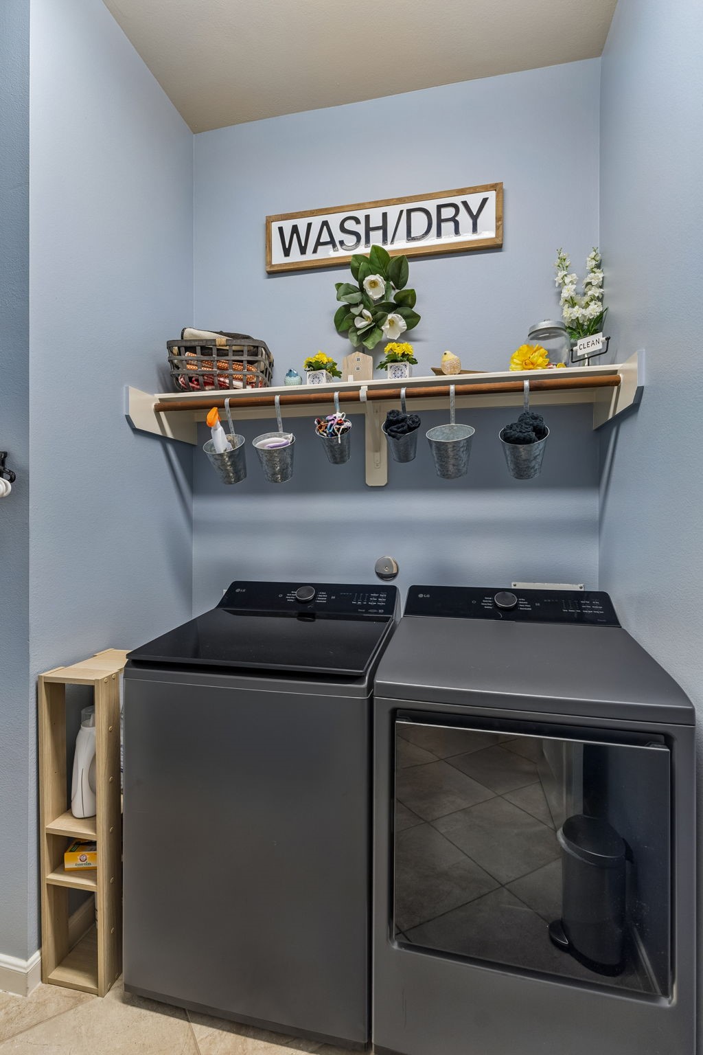 Dedicated laundry area with full-size washer and dryer, overhead shelving, and convenient storage space.