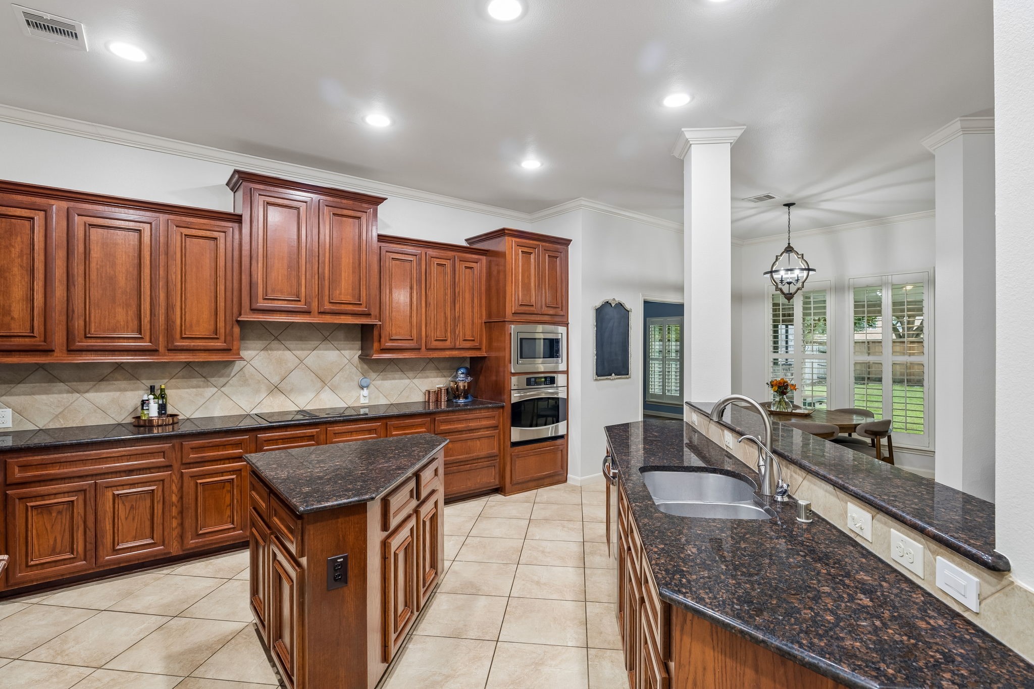 Alternate kitchen view highlighting the center island, generous workspace, and abundant cabinetry.
