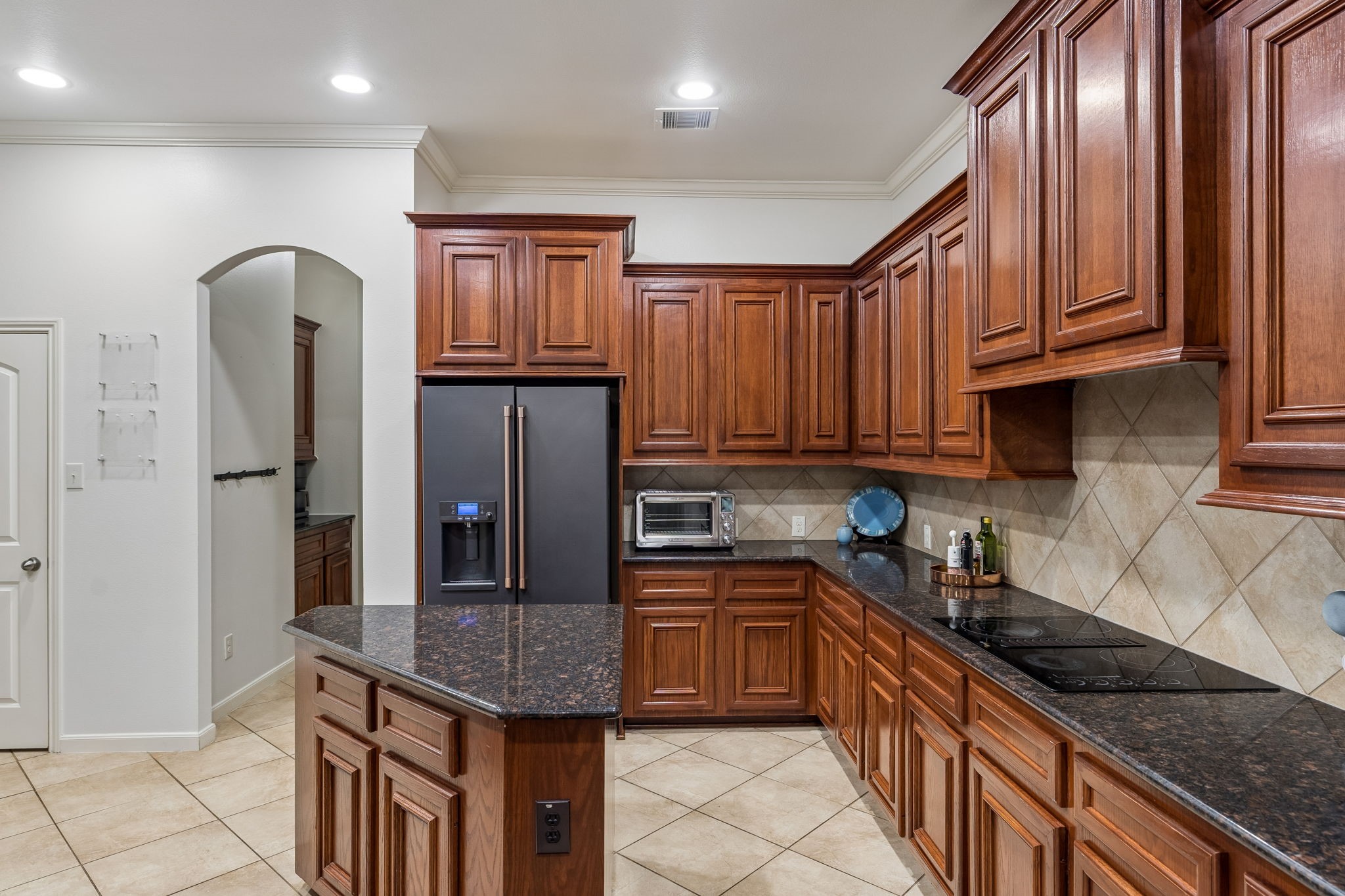 Well-equipped kitchen with stainless steel appliances, extensive cabinetry, and ample counter space.